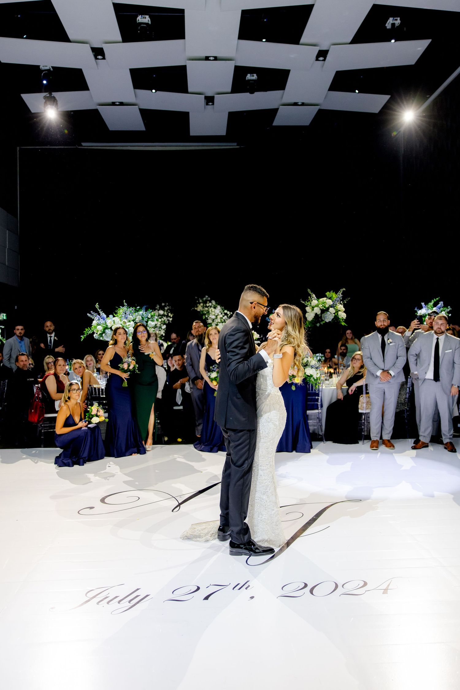A wedding dance moment captured on July 24th 2021 with guests in navy and grey watching.