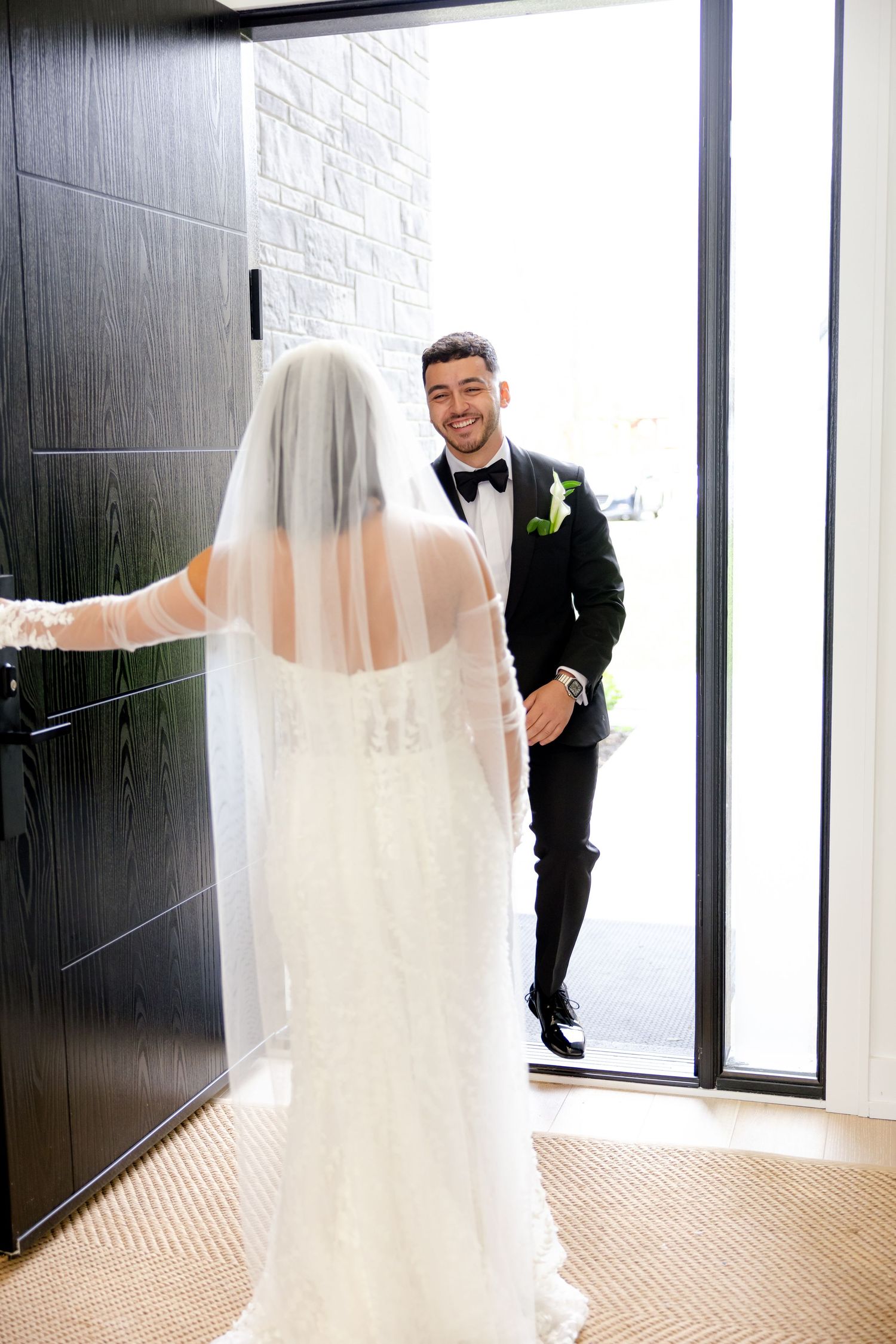 A candid first look moment between newlyweds at a modern venue doorway.