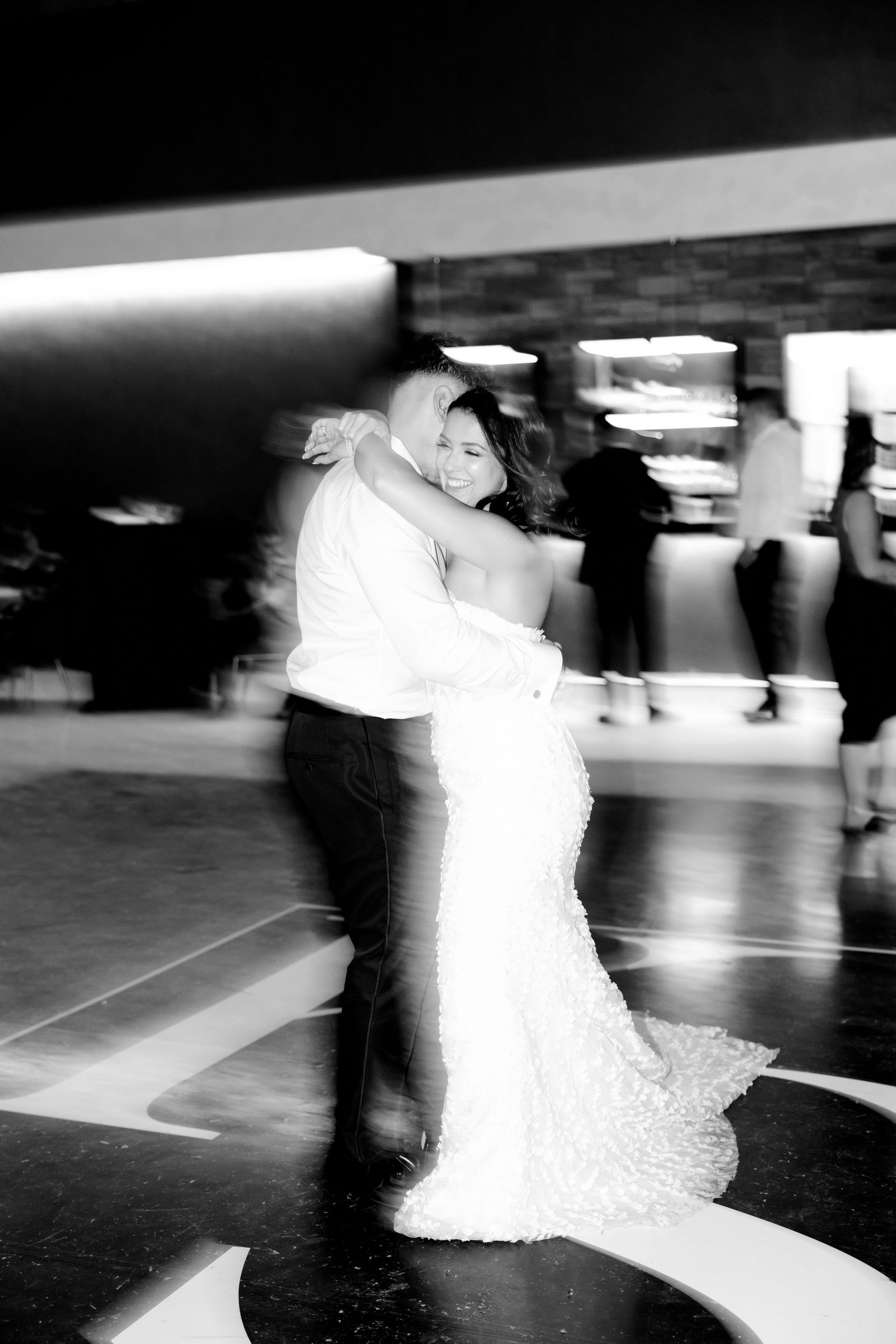 Artistic motion blur of a couple sharing an intimate dance moment at their wedding reception.