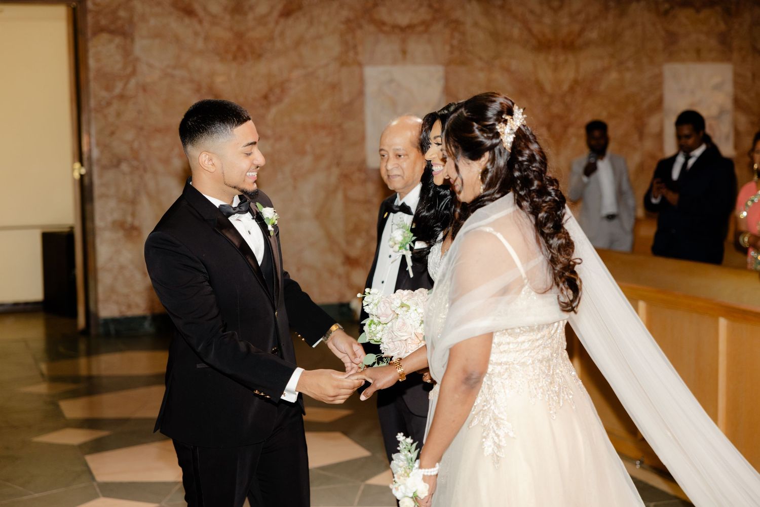 Intimate moment captured during wedding ceremony as couple holds hands at the altar.