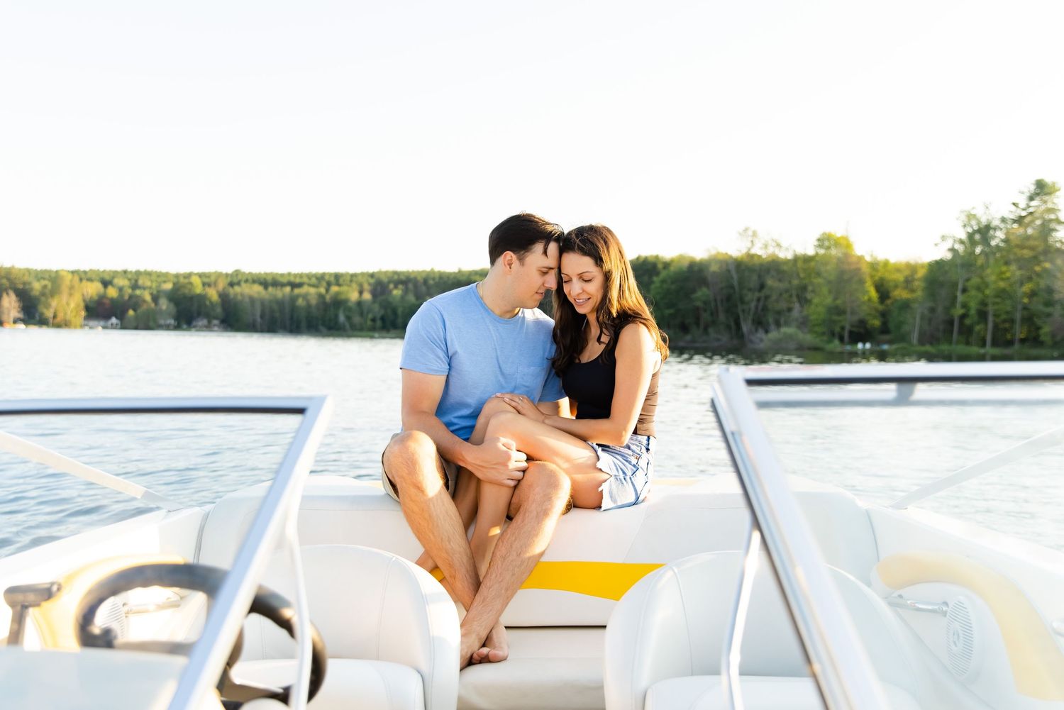 Intimate moment between a couple sitting on a pontoon boat deck at golden hour.