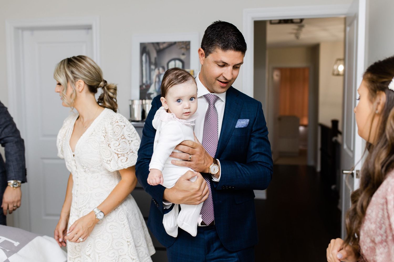 A group in formal attire gathered in a bright indoor setting.