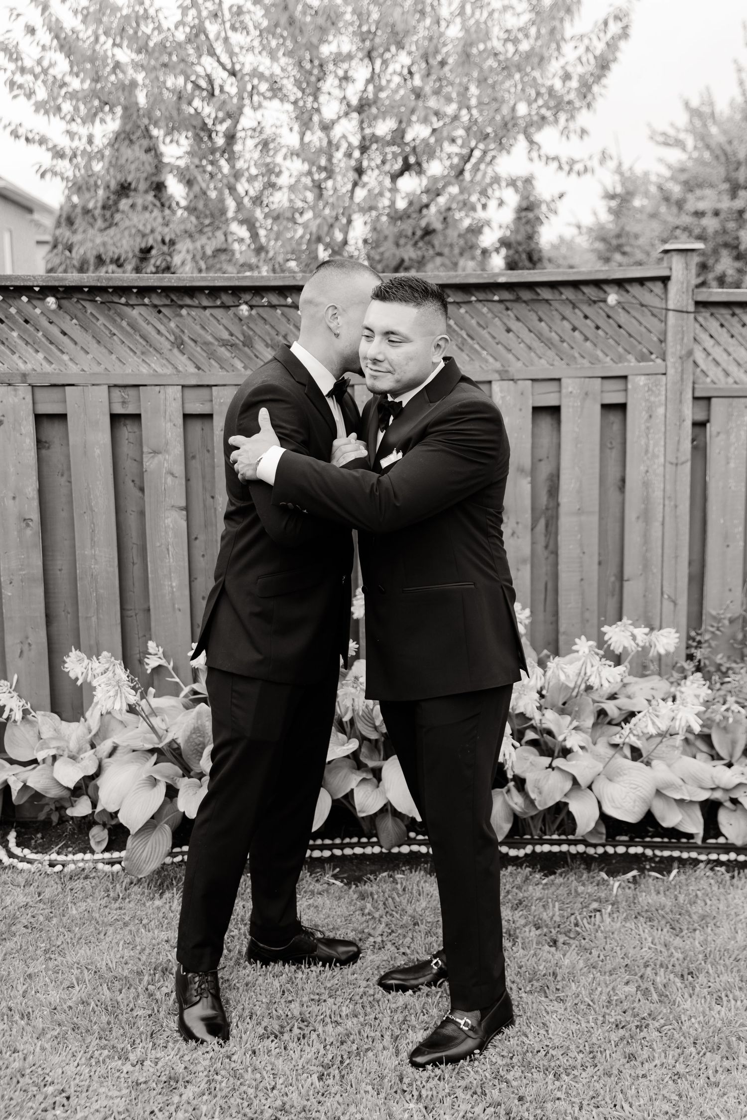 A sequence of black and white photos showing two men in suits playfully creating a dance scene in a backyard garden.
