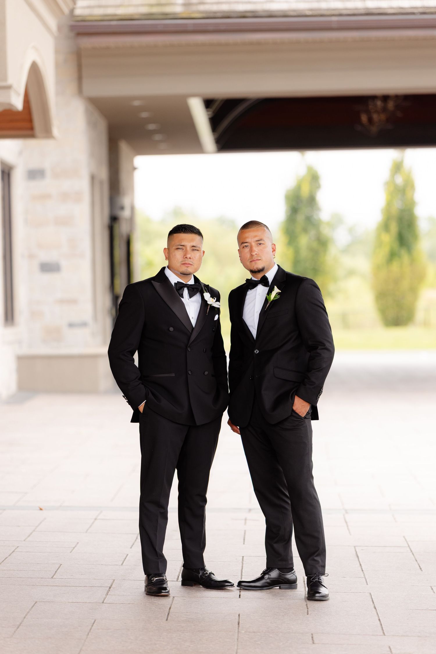 Three matching views show pairs of groomsmen playfully posing in black tuxedos at a wedding venue.