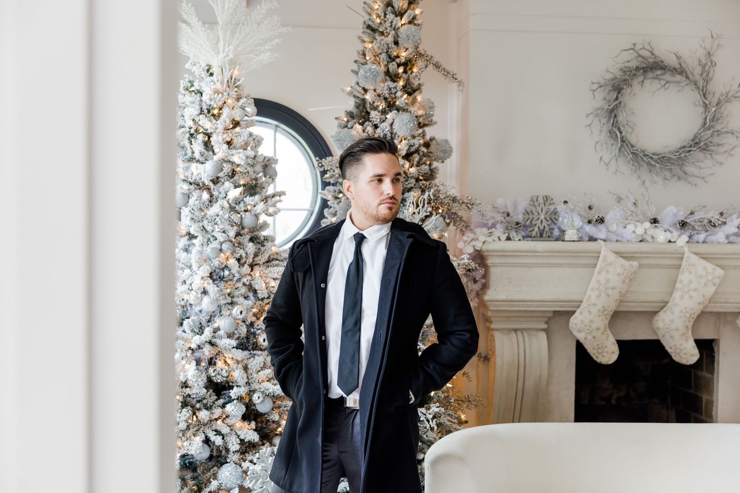Stylish winter fashion photo with black coat and tie against decorated Christmas trees.