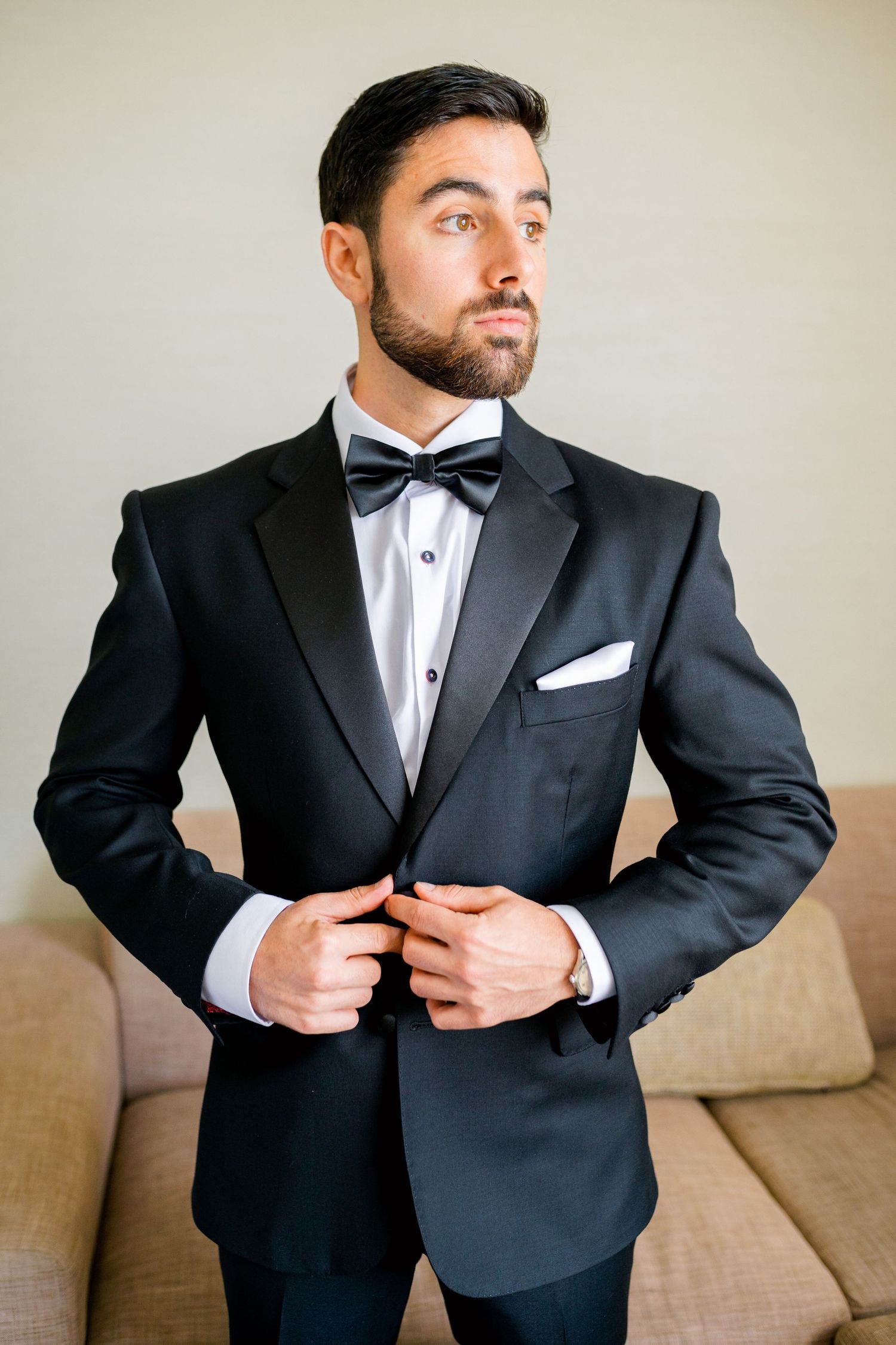 Close-up portrait of person wearing classic black tuxedo with bow tie.