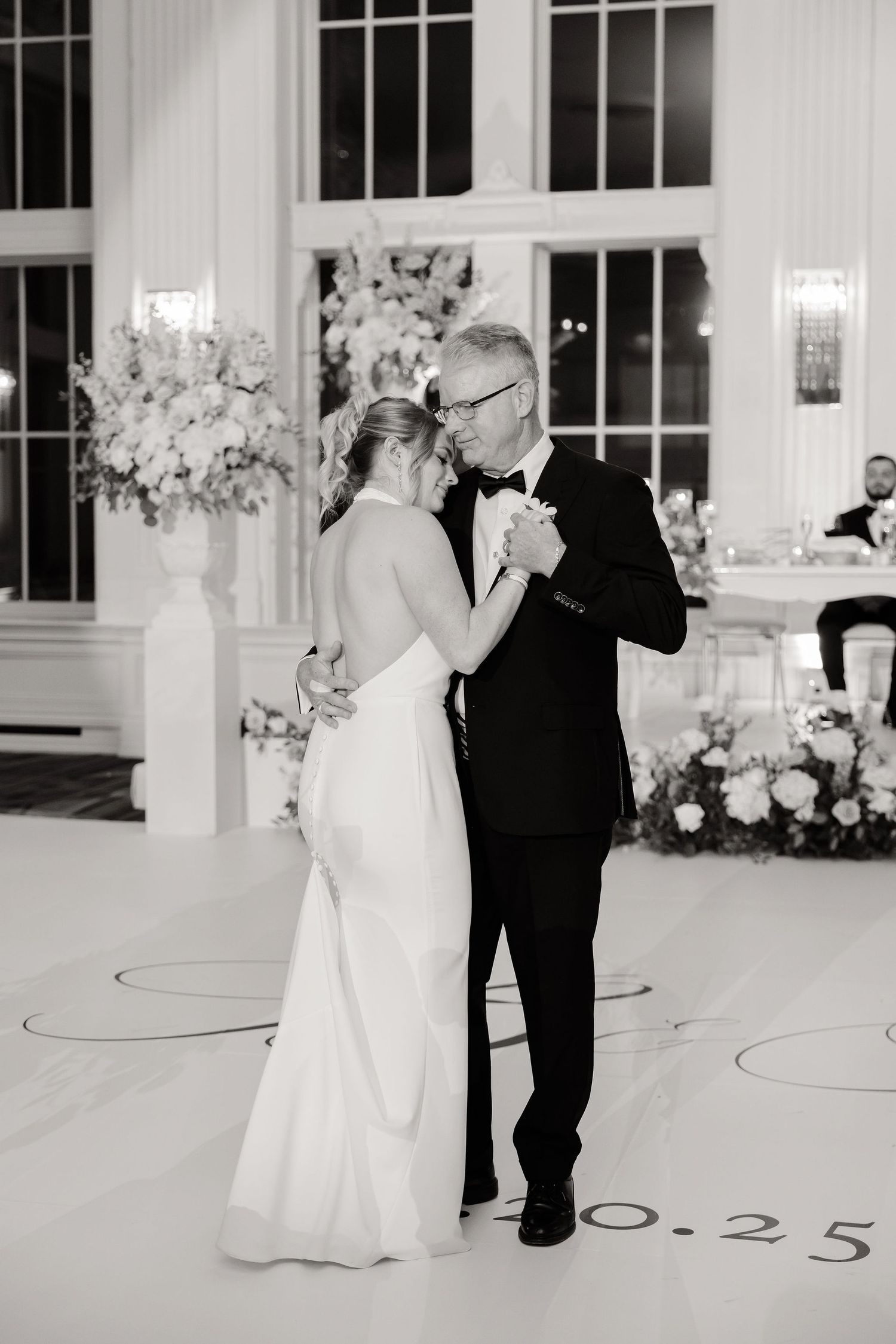 Black and white sequence of a wedding couple's first dance in an elegant ballroom setting.