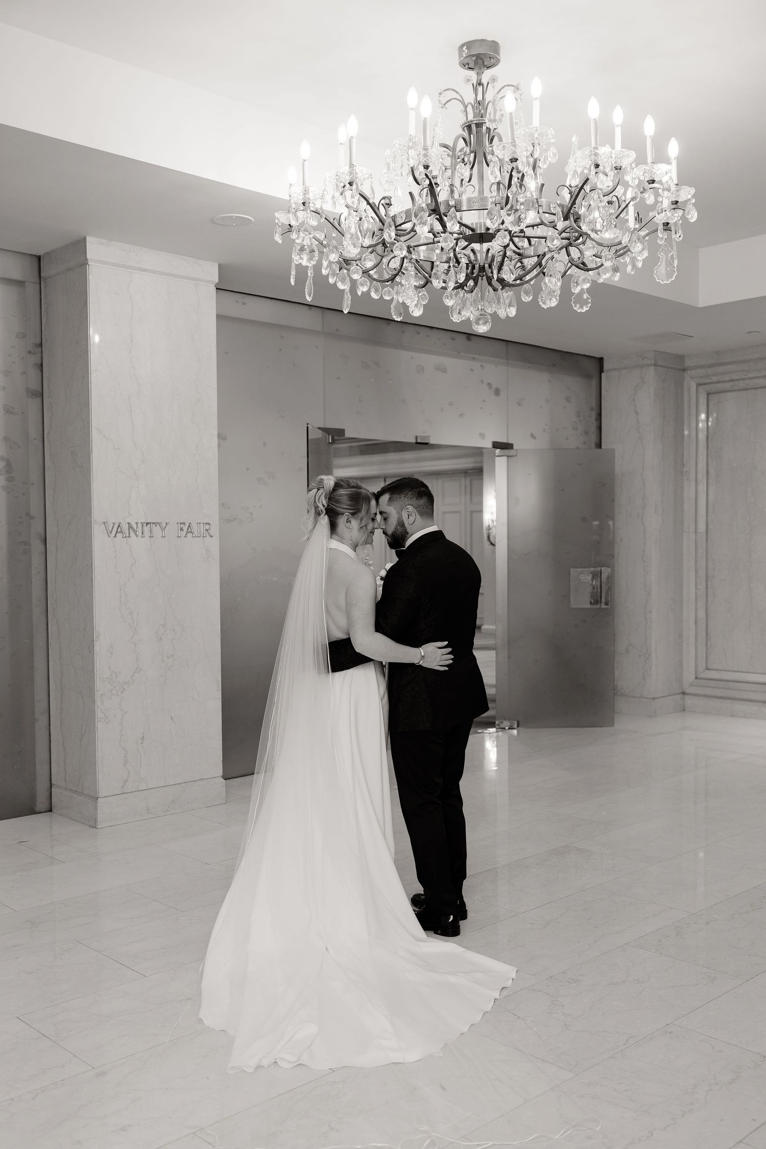 A series of wedding photos in an elegant white room with crystal chandeliers showing a first look moment.