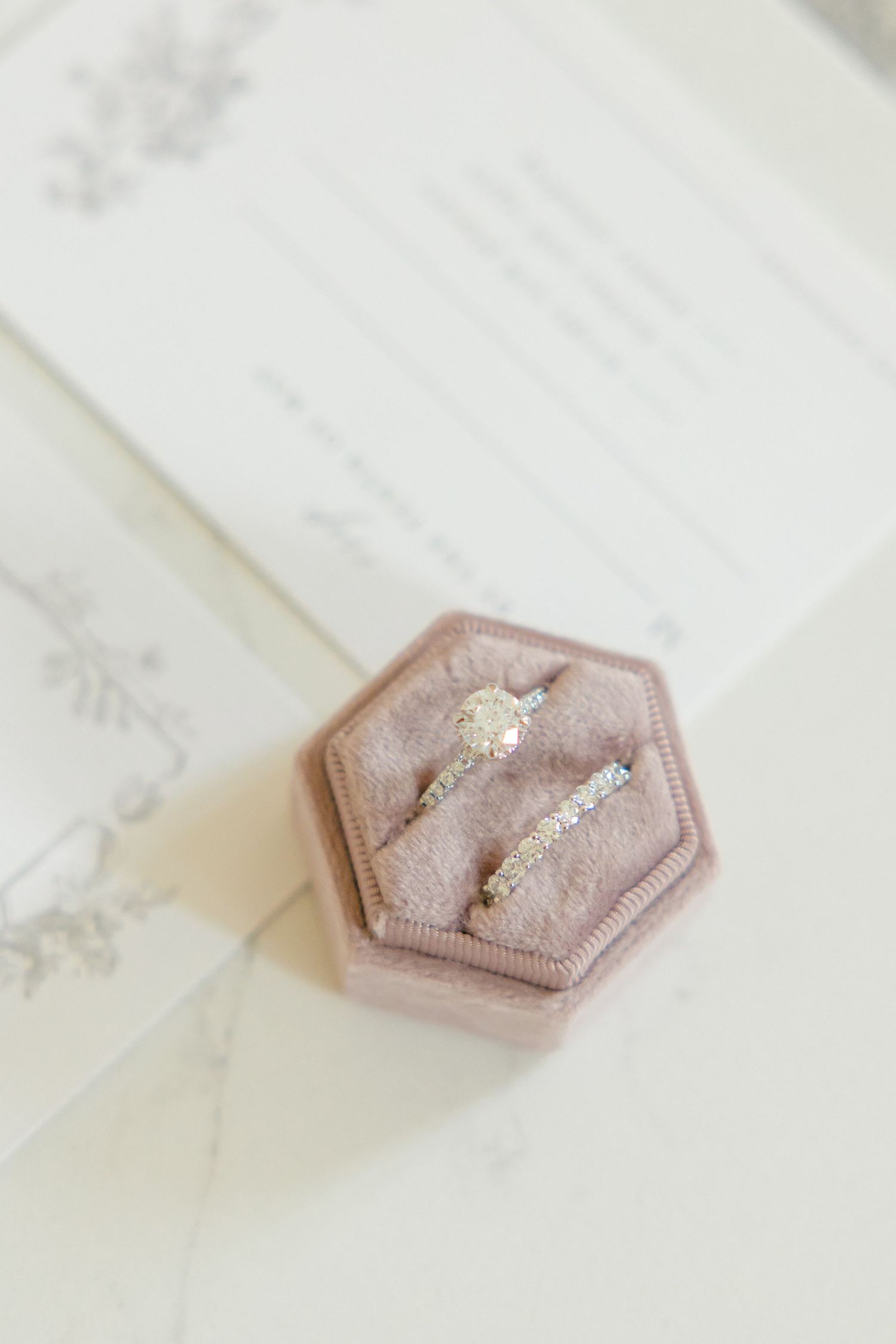 Diamond engagement ring and wedding band in pink hexagonal velvet ring box.