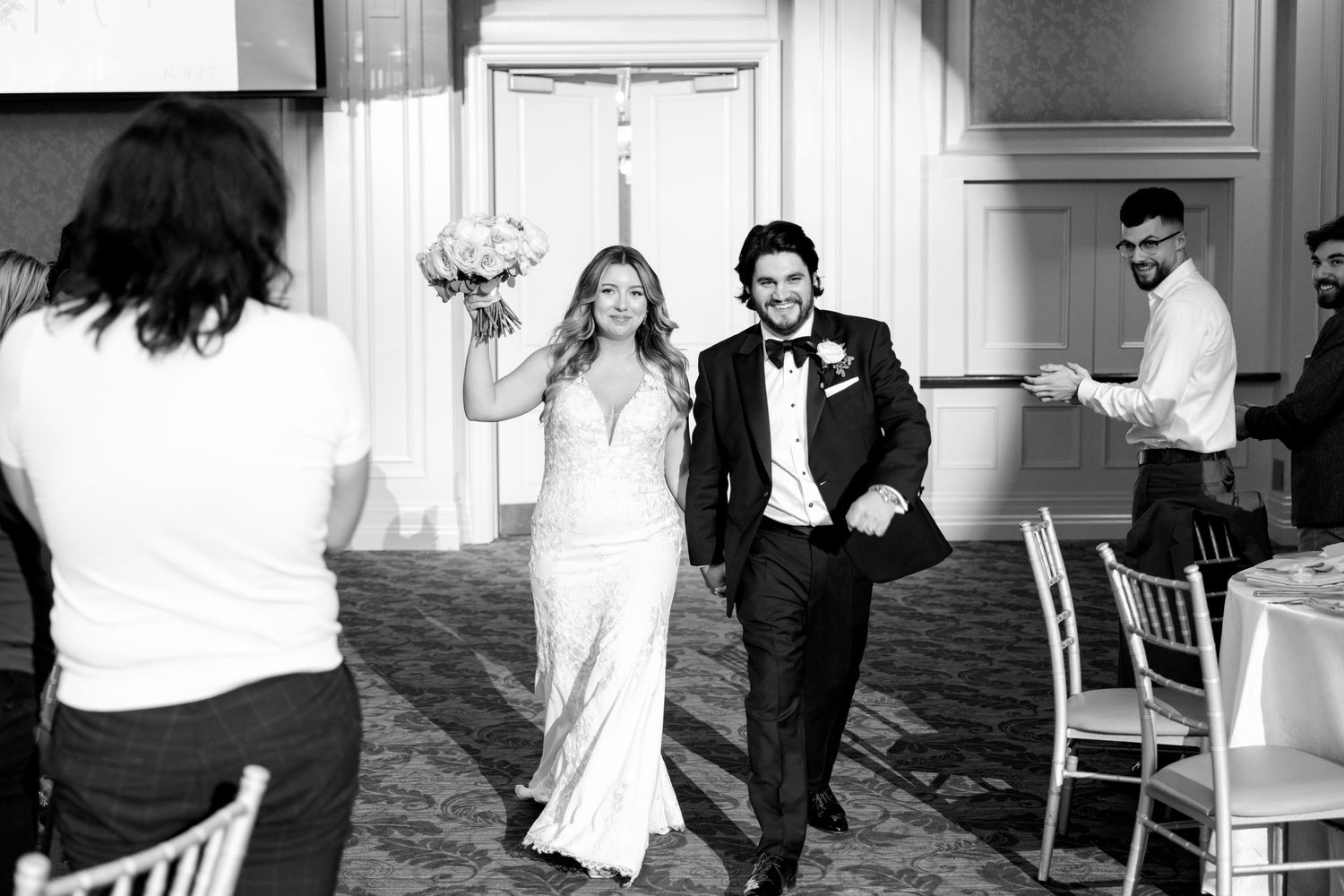 Newlyweds make their grand entrance into wedding reception with joyful celebration.