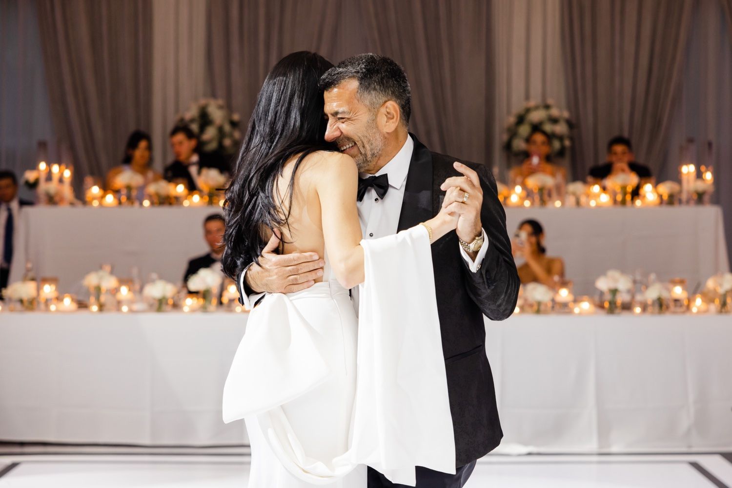 Newlyweds share intimate dance moment on their wedding day in an elegantly decorated ballroom.