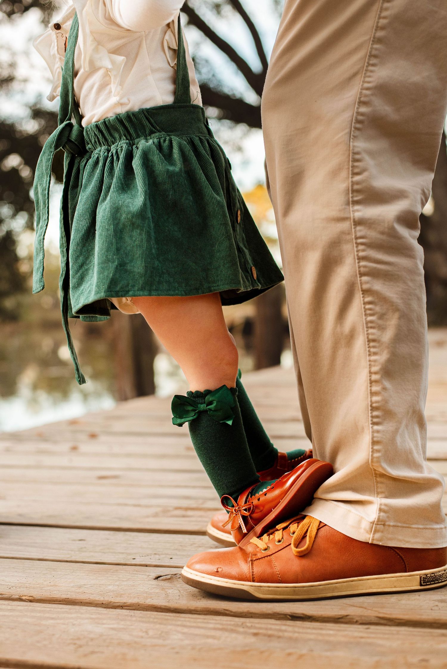 Father daughter photo, daughter stands on father's feet  while they dance on a deck in moss point mississippi Christmas