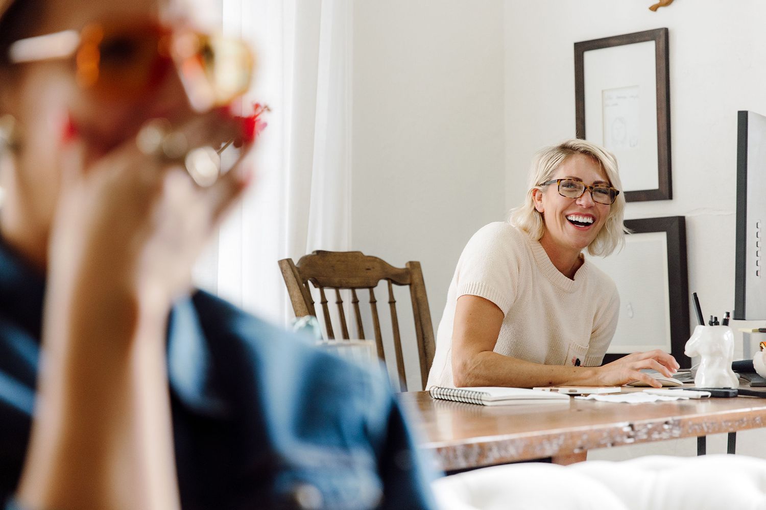 Candid moment of laughter during a casual business meeting at a wooden table.