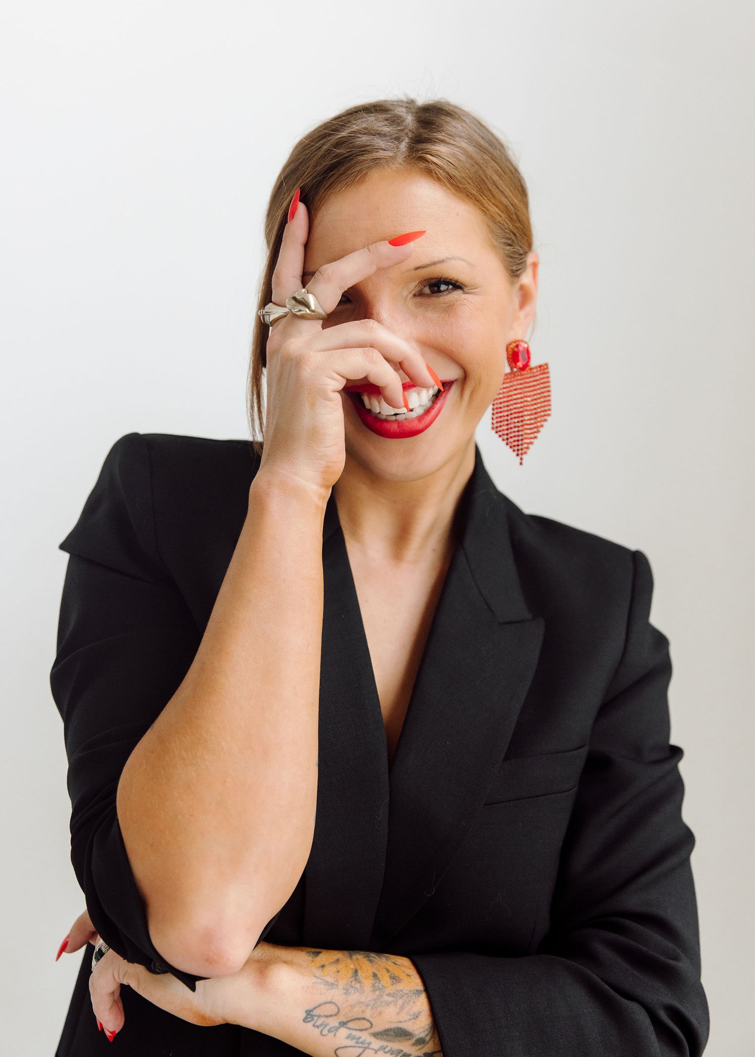 Professional headshots of woman in black blazer with red nails and playful expressions.