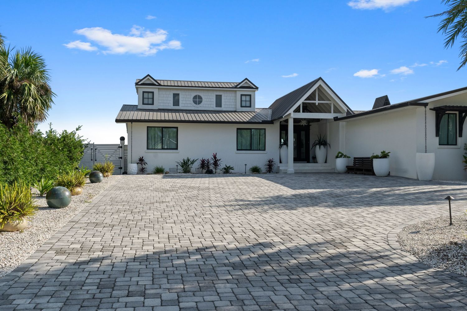 Beauitful home with blue skys and nice brick driveway.