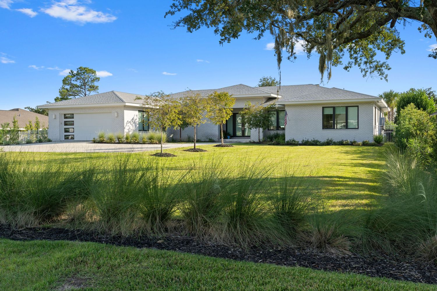 Modern white house with a beautiful lawn.