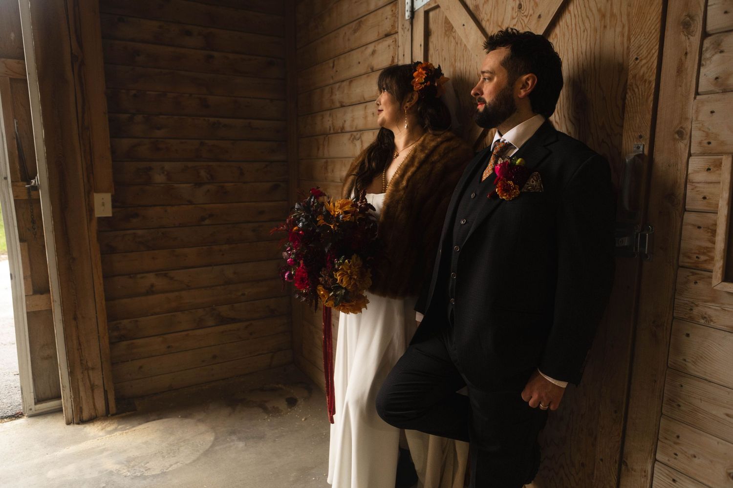 A wedding ceremony takes place in a rustic brick-walled venue with natural light streaming through white curtained windows.