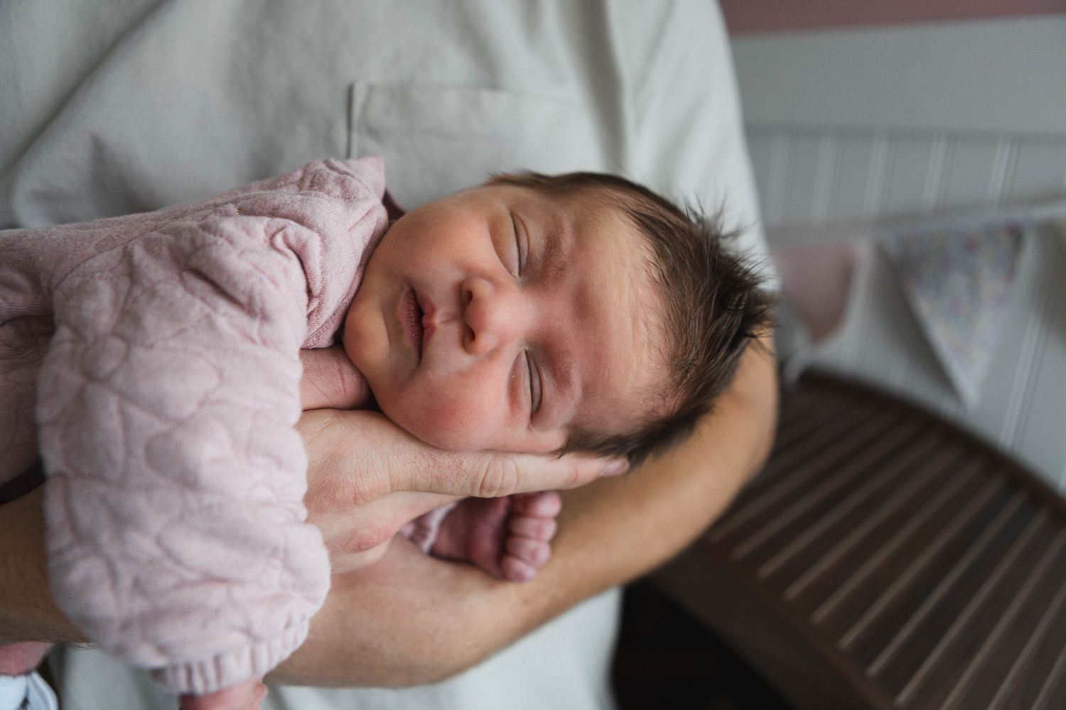 Parent and newborn baby sleeping peacefully together in hospital bed.