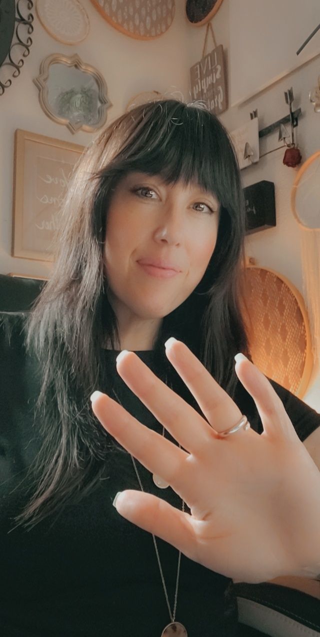 Owner of Knot Planned Photography, Kelly Kreis sitting at her desk with her hand up as to signal she's saying hello with
