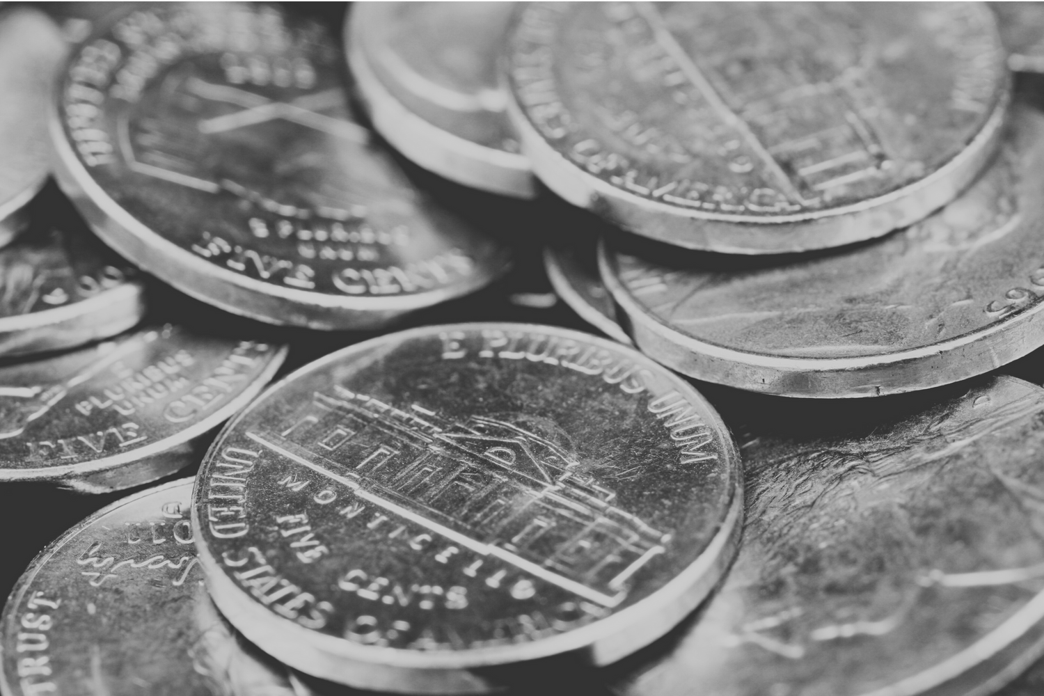 Black and white pile of nickels from the US currency.