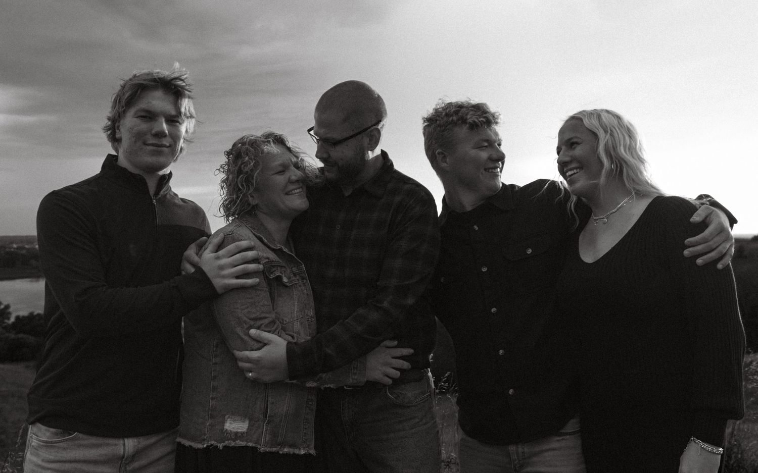 Black and white panoramic group photo outdoors with dramatic cloudy sky.