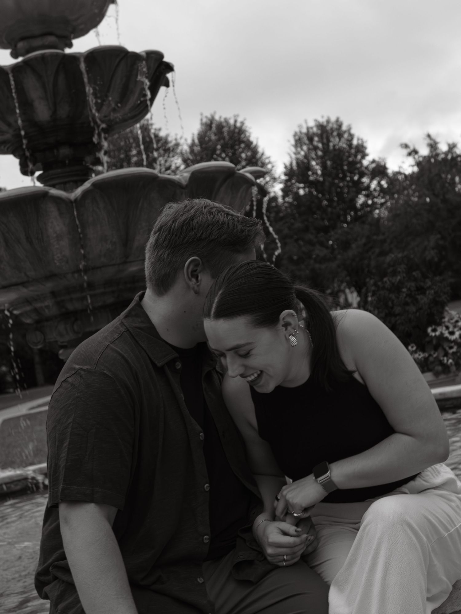 A couple shares affectionate moments together in black and white photography.