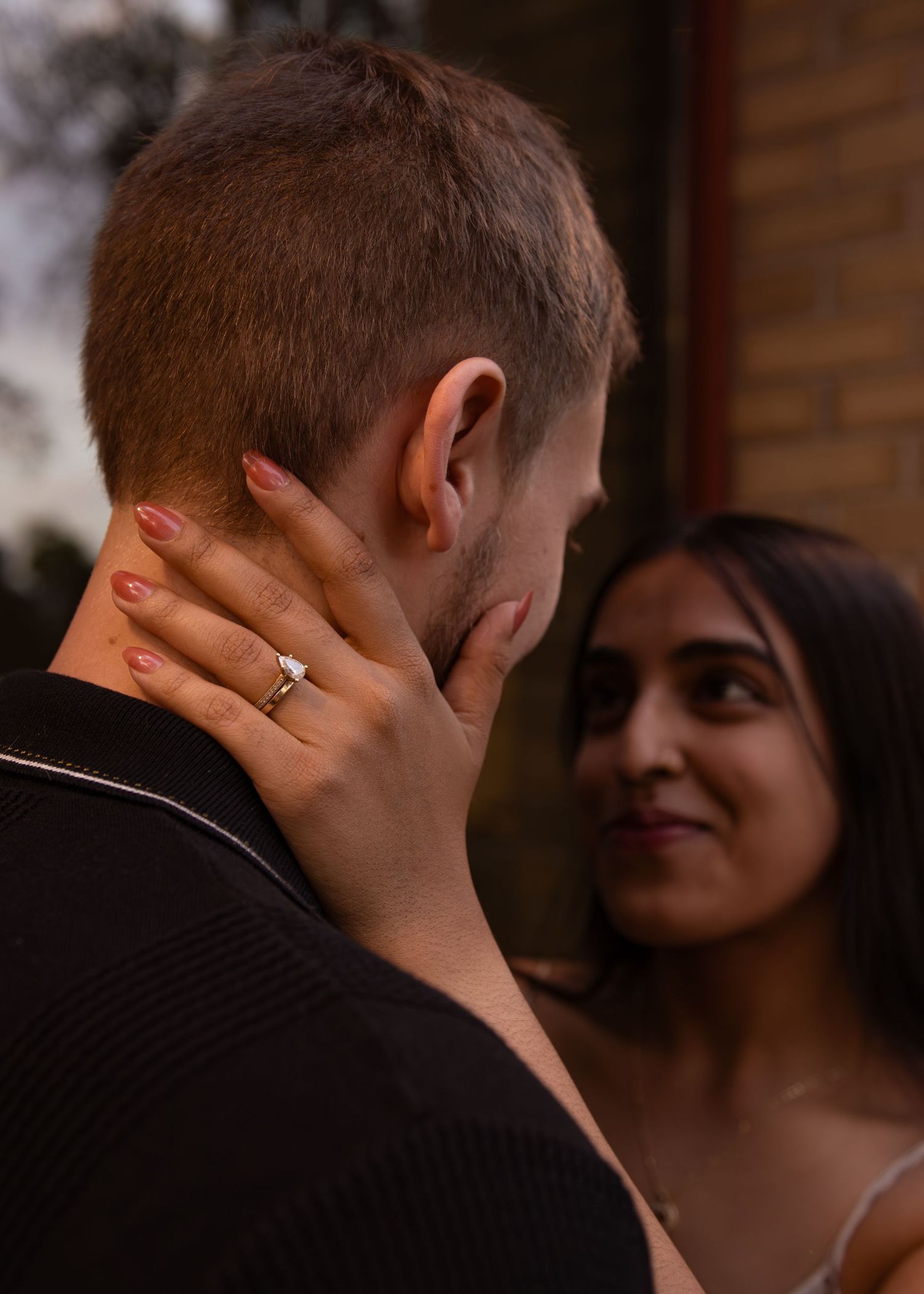 Close-up of hands and intimate embrace in warm indoor lighting.