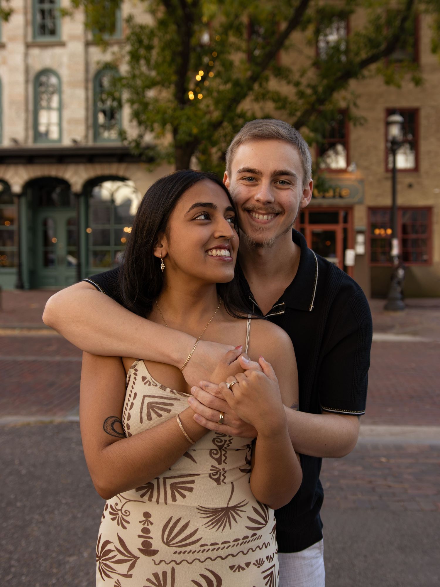 Couple embracing and laughing together in an urban setting.