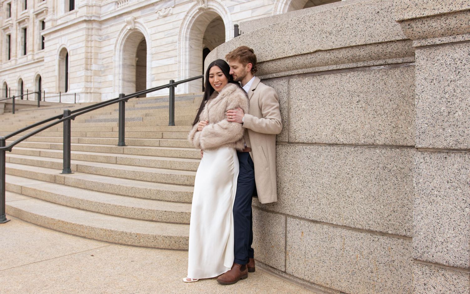 A series of romantic photos showing a couple sitting and embracing on grand stone steps of a building.