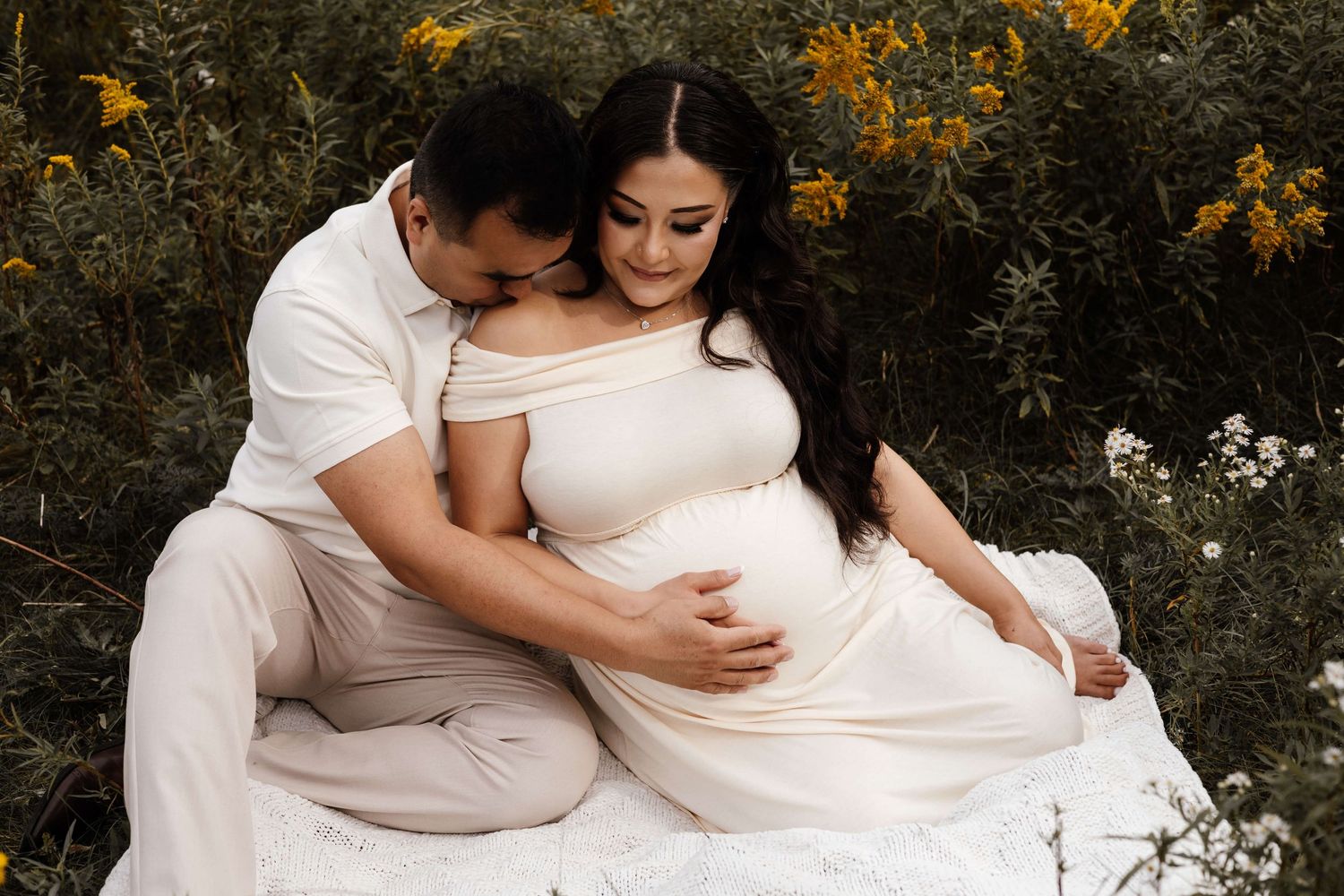 Expectant parents sharing a quiet moment during an outdoor maternity photography session at Evergreen Brick Works in Toronto.