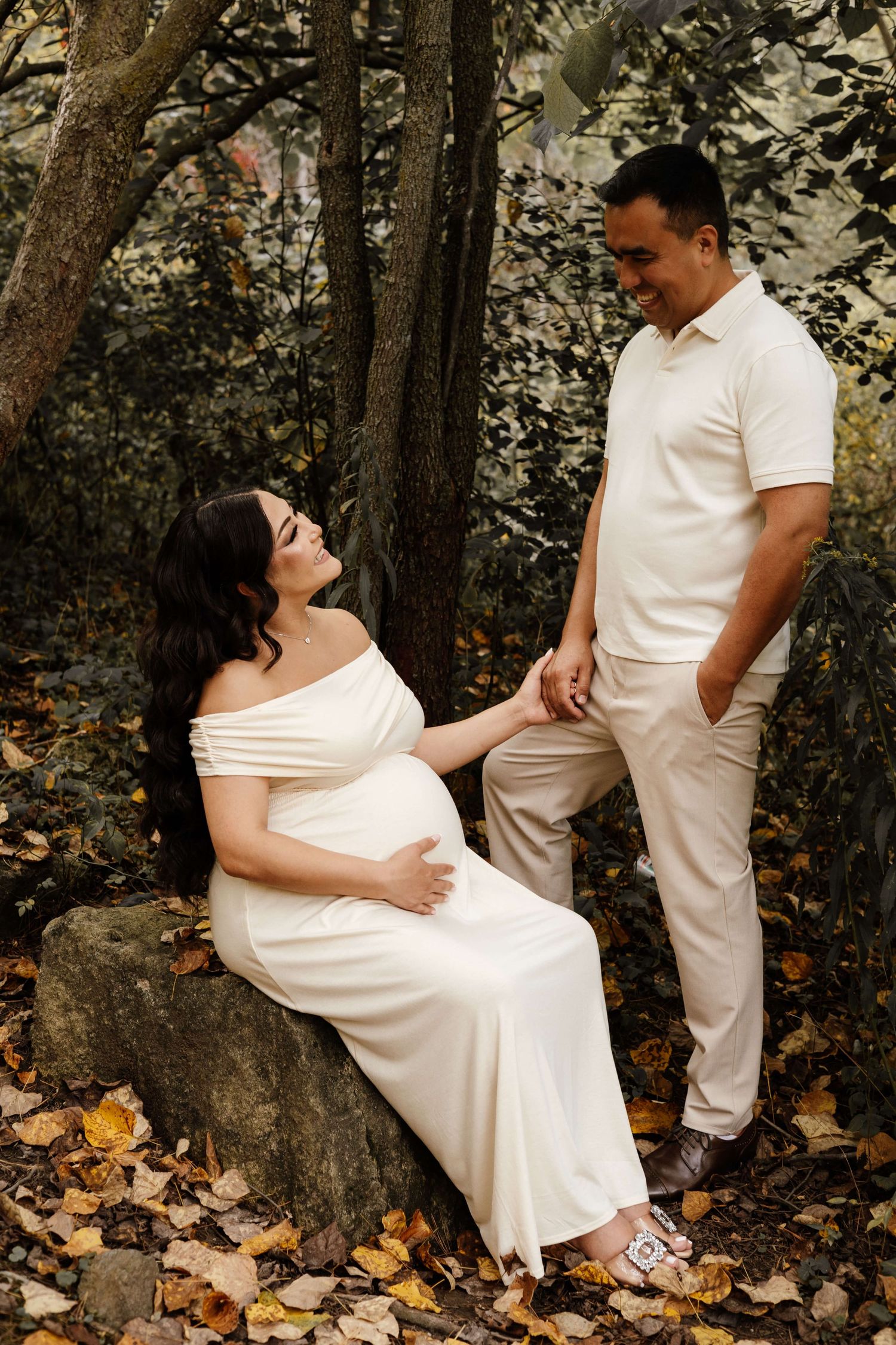 Expectant parents holding hands at Evergreen Brick Works during an outdoor maternity photography session in Toronto.