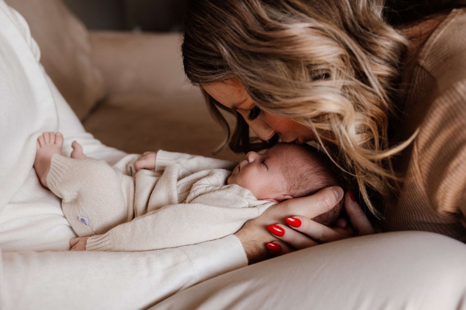 Mother kissing her newborn during an in-home newborn photography session in Toronto, capturing love, connection, and tenderness.
