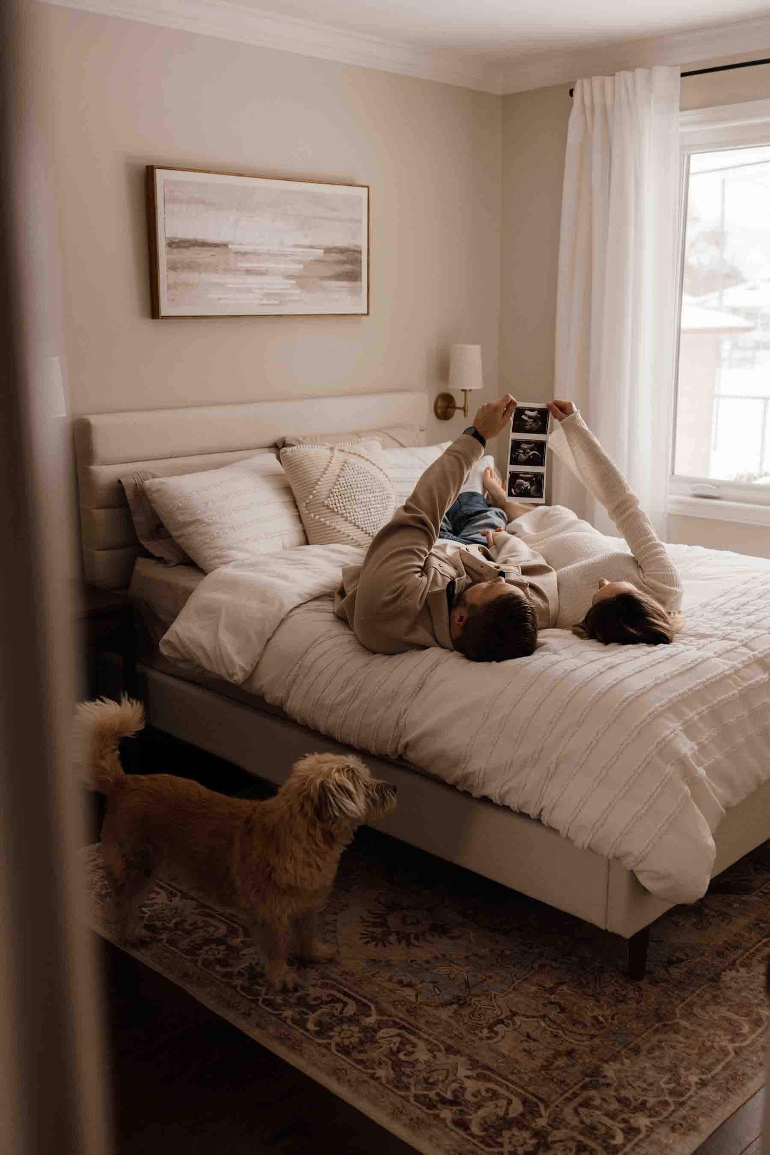 Expectant parents sharing an intimate moment on the bed during an in-home maternity photography session in Toronto, celebrating anticipation