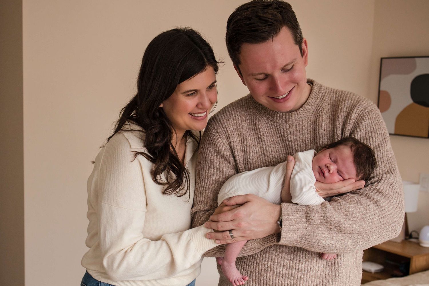 New parents admiring their newborn during a natural lifestyle newborn photography session in Toronto.