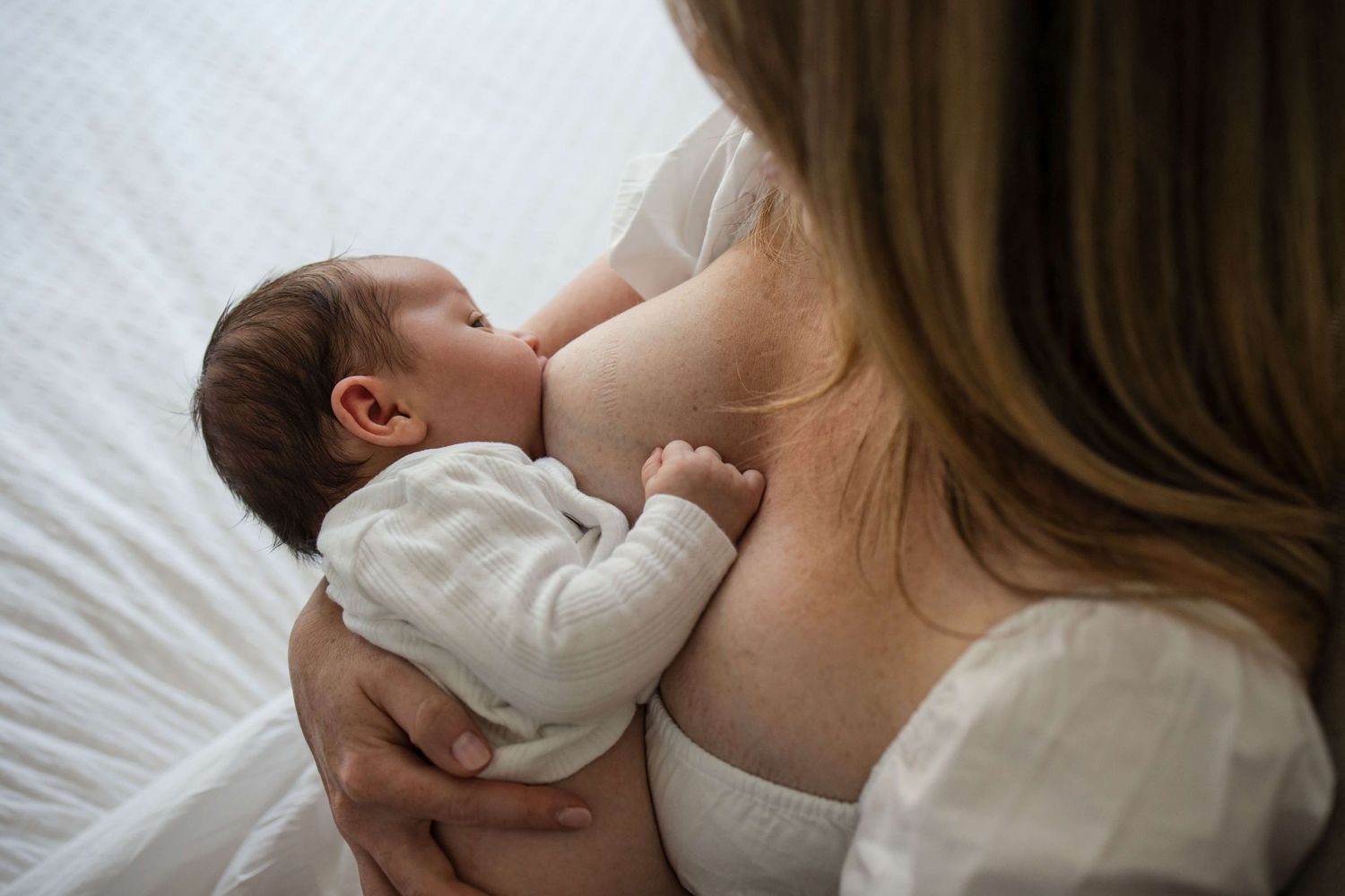 Breastfeeding mother and newborn sharing a quiet bonding moment at home in Toronto.