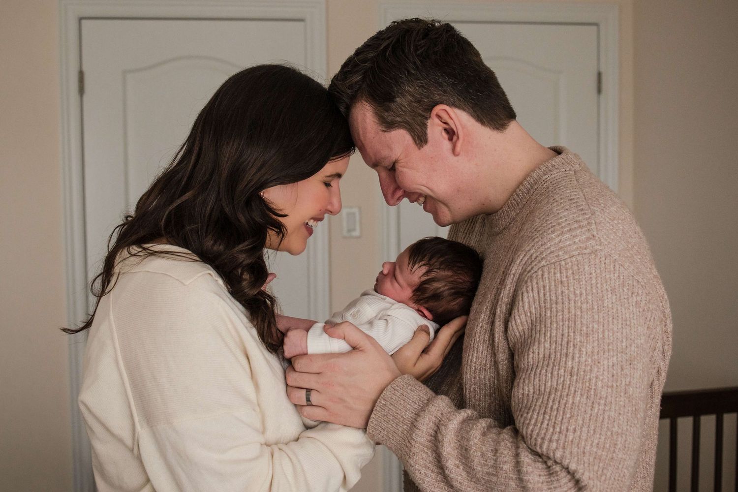 New parents admiring their newborn during a natural lifestyle newborn photography session in Toronto.