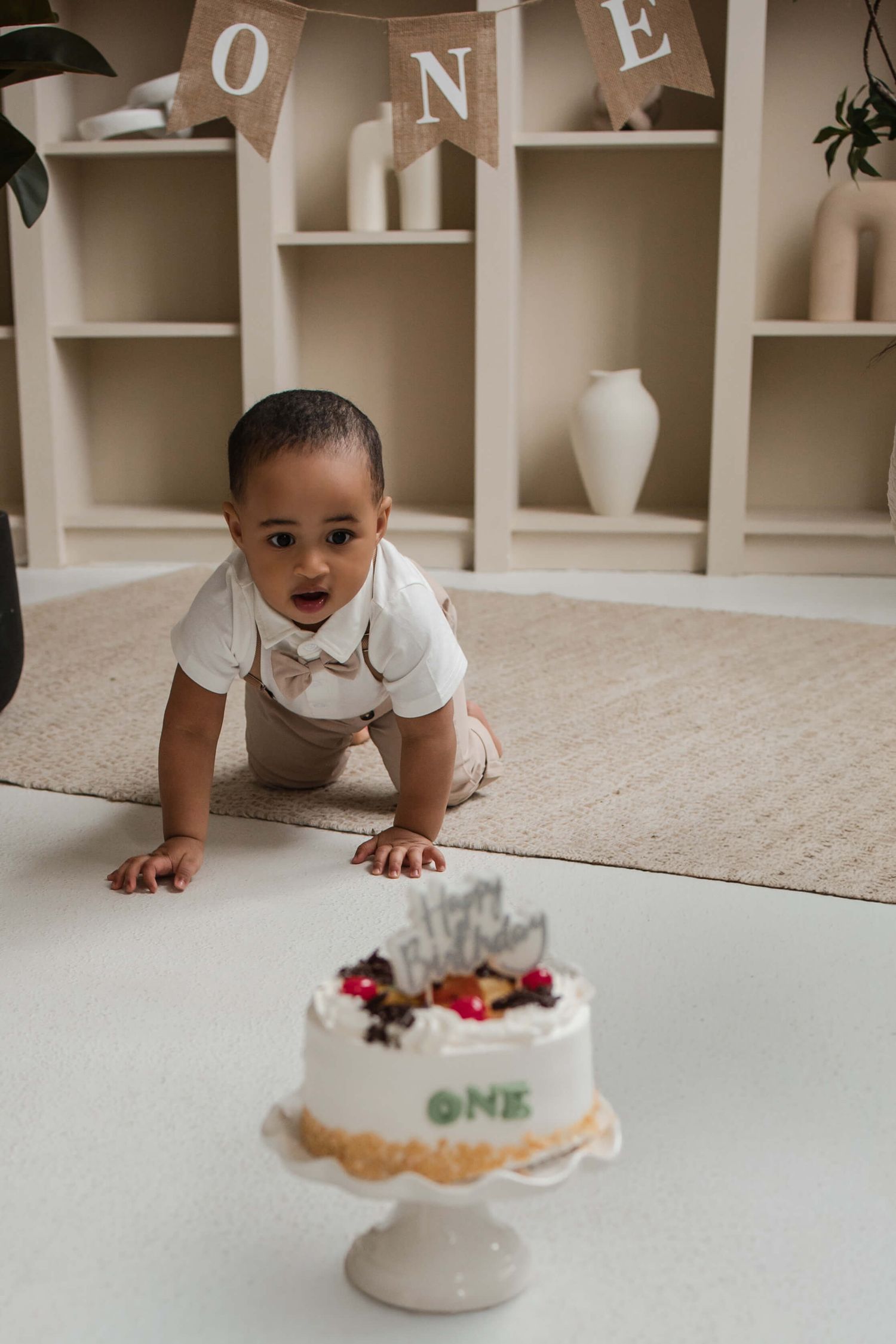 One-year-old enjoying a cake smash session at Mint Room Studios in Toronto with a simple neutral setup, timeless decor, and natural style.