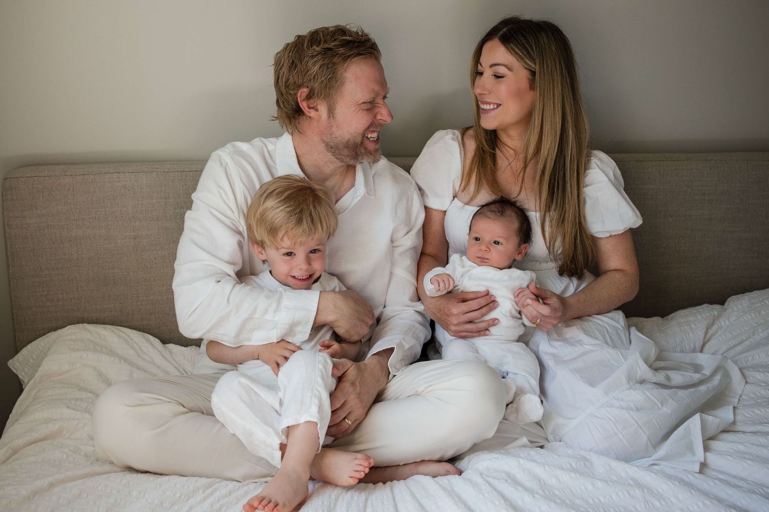 Parents and toddler welcoming their newborn during a lifestyle newborn session at home.
