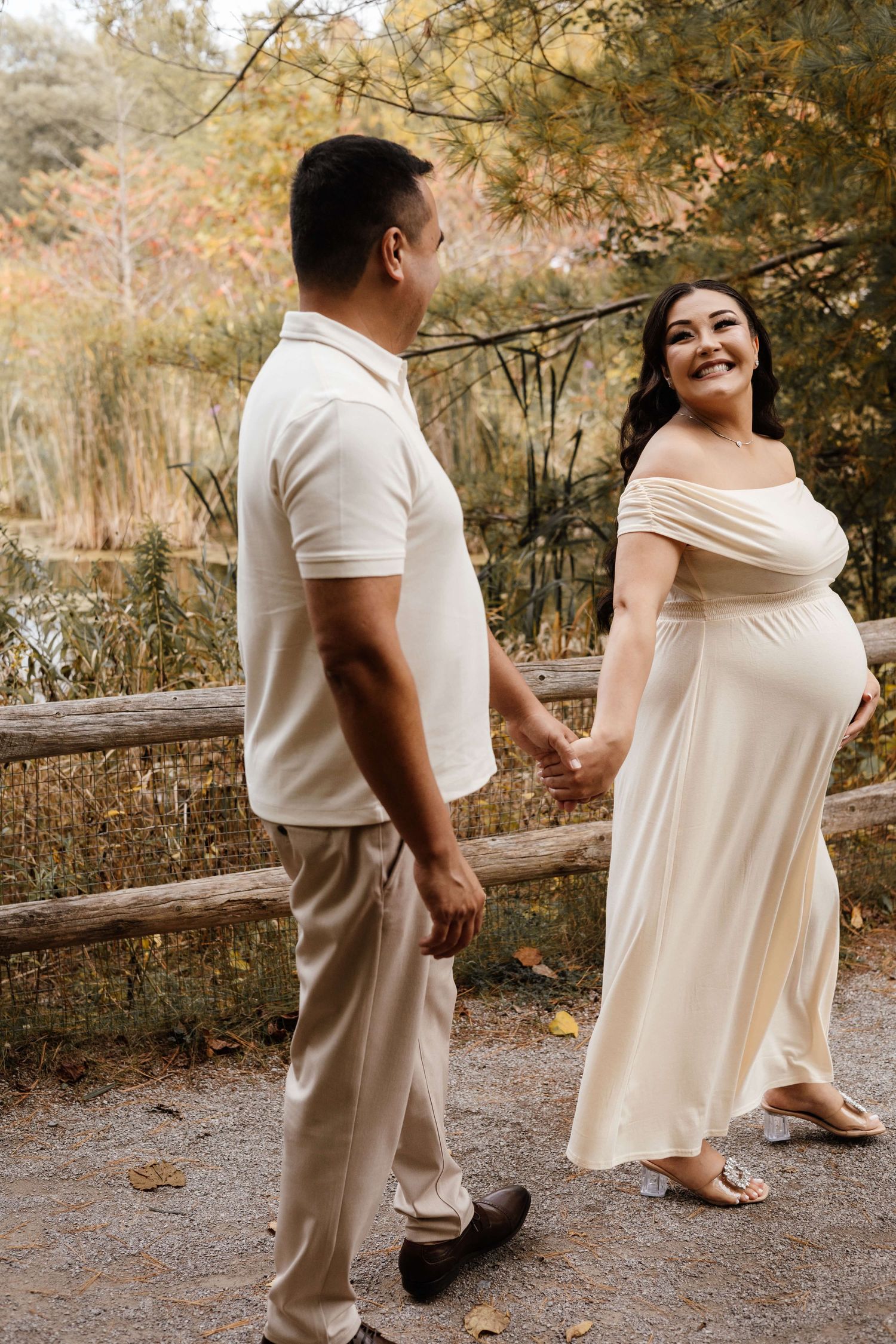 Expectant parents sharing a joyful moment at Evergreen Brick Works during an outdoor maternity photography session in Toronto.