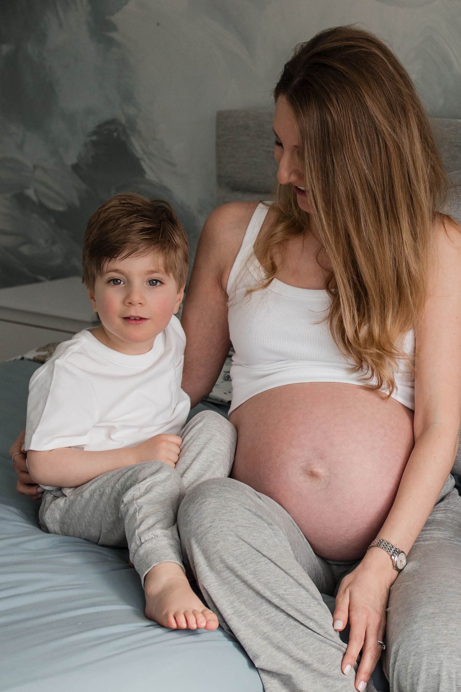 Expectant mother sharing a quiet moment with her child during an in-home maternity photography session in Toronto, celebrating family.