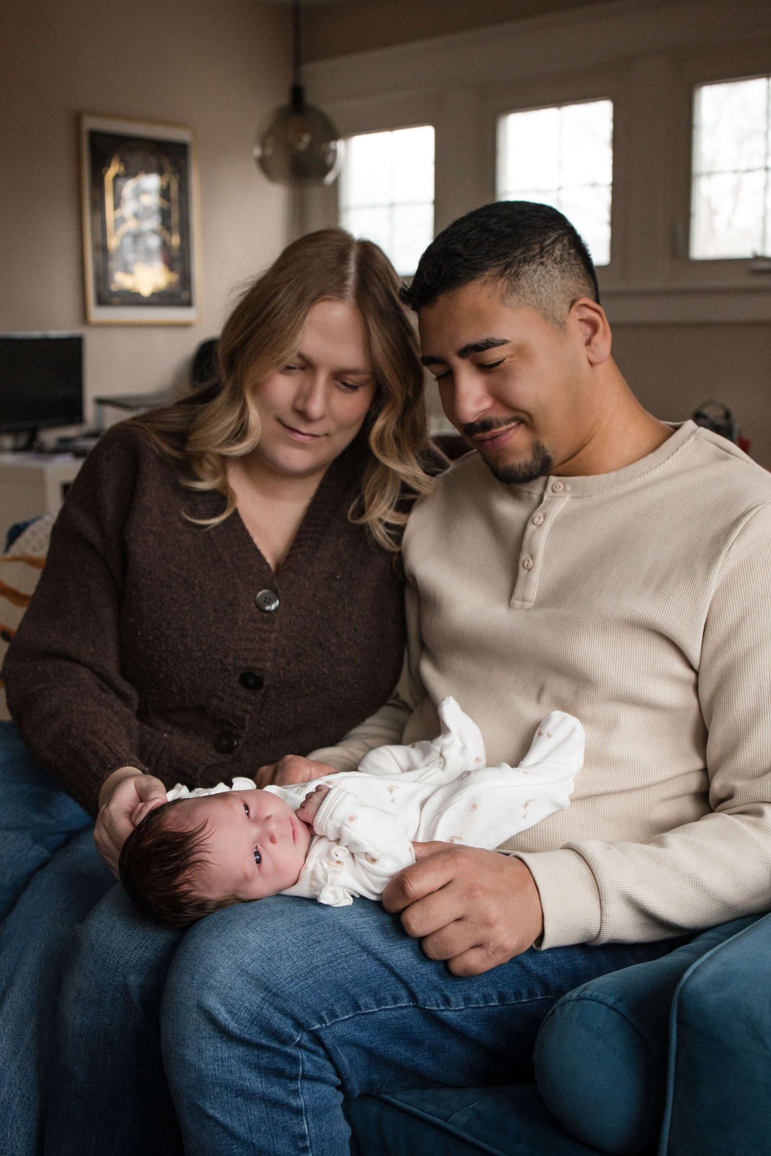 Parents admiring their newborn during an in-home newborn photography session in Toronto, capturing love, connection, and new beginnings.