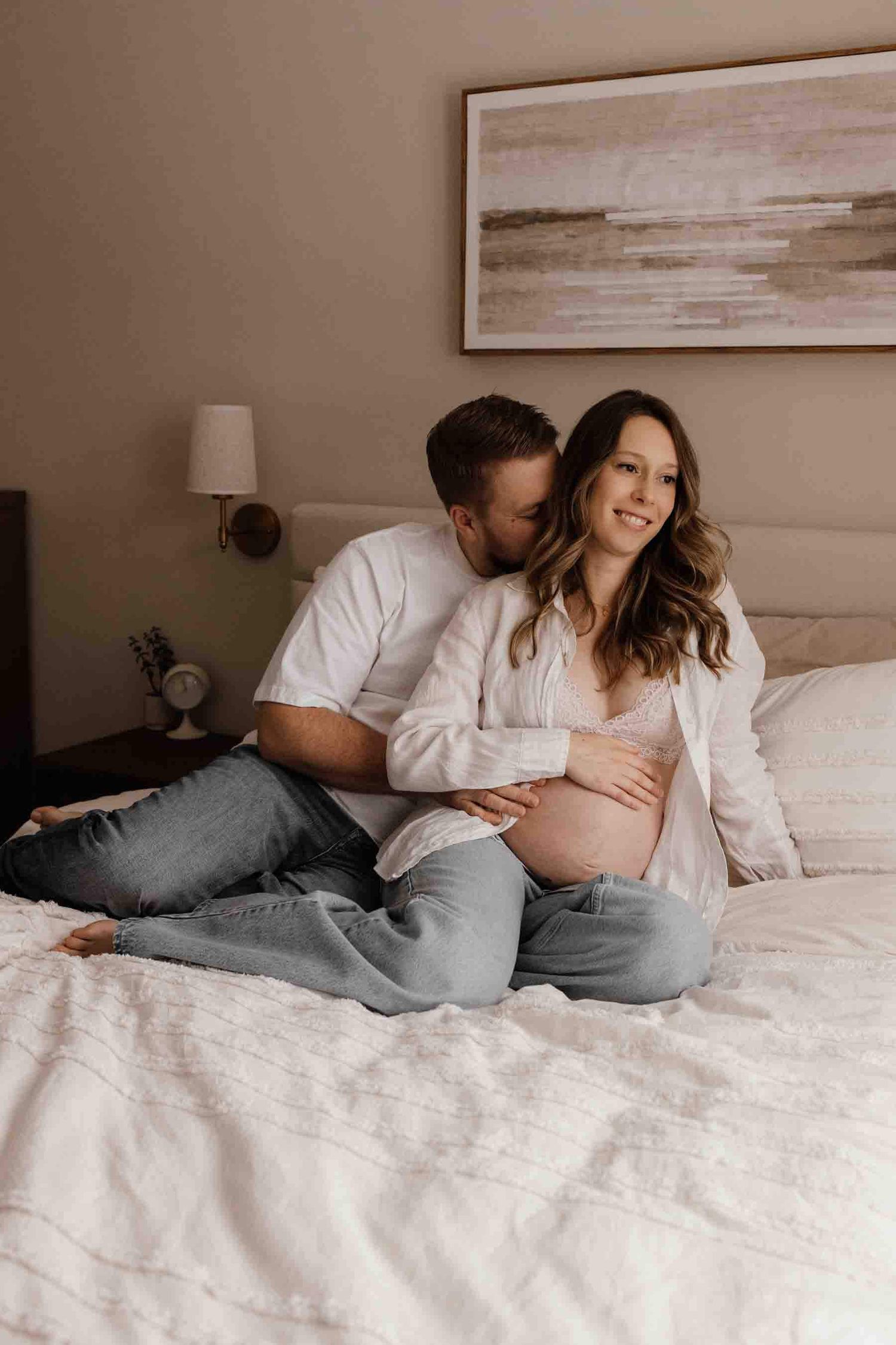 Expectant father kissing the baby bump during an in-home maternity photography session in Toronto, celebrating parenthood.