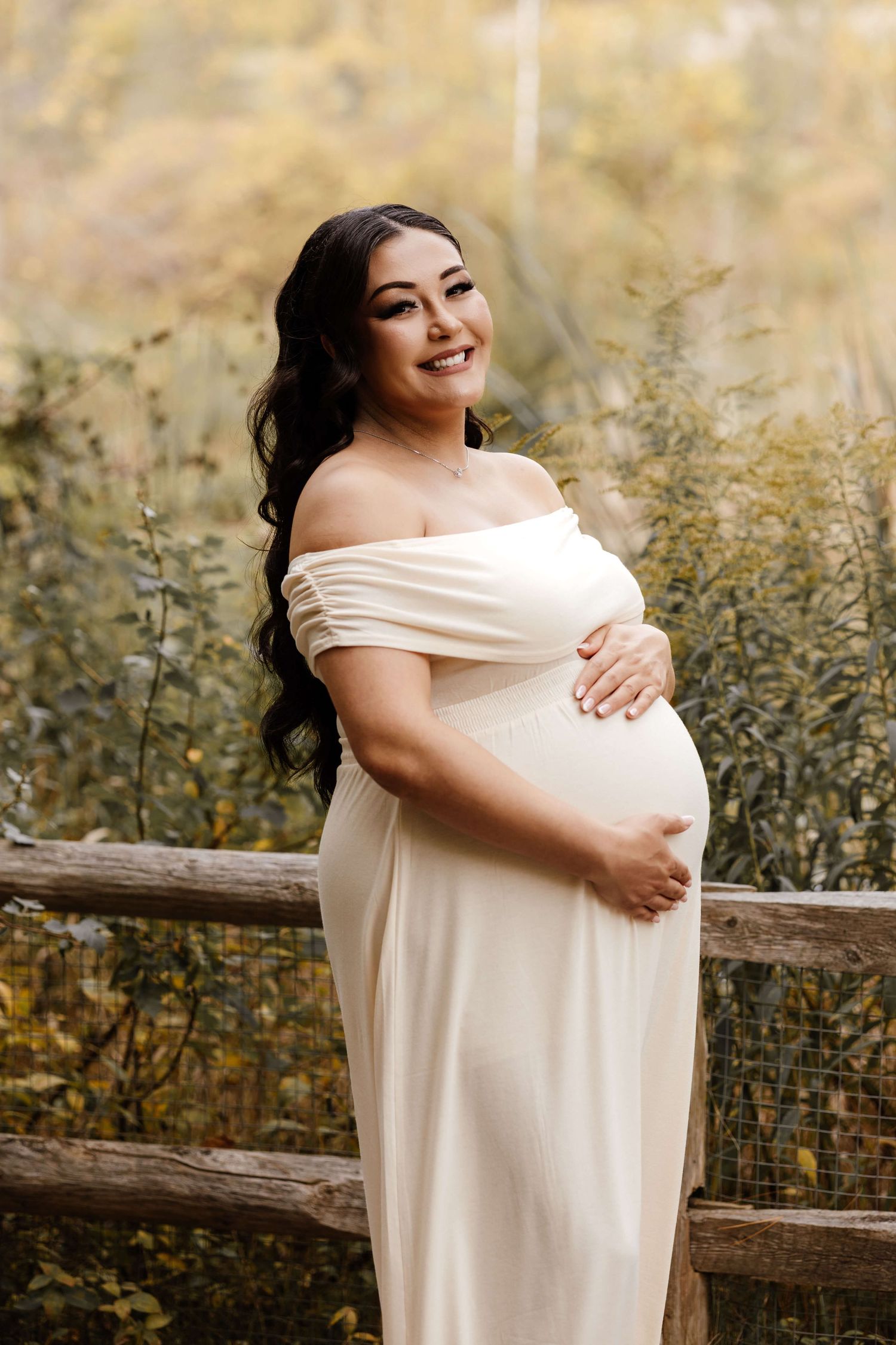 Expectant mother embracing her growing baby bump at Evergreen Brick Works during an outdoor maternity photography session in Toronto.