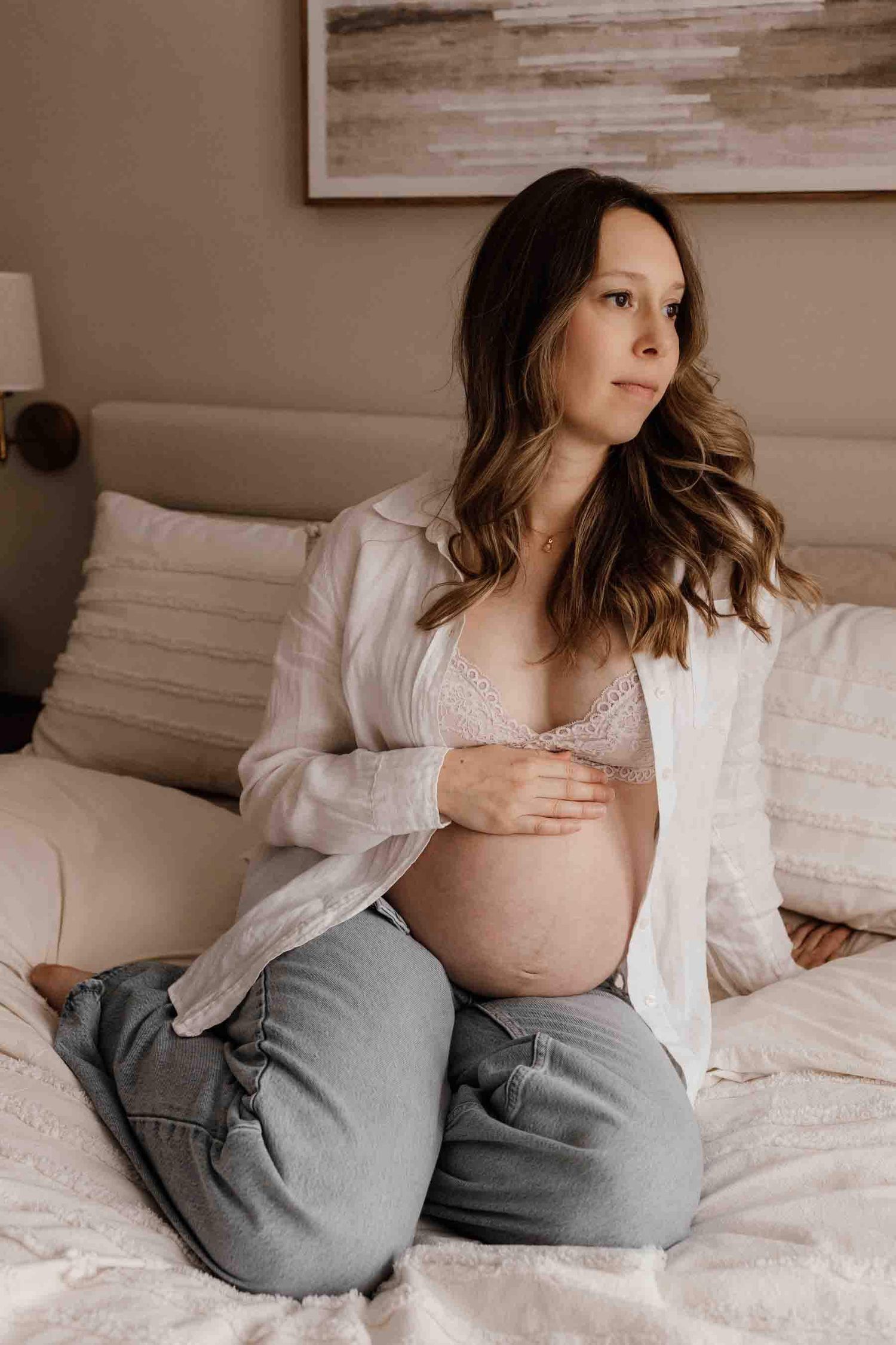 Expectant mother reflecting on motherhood during an in-home maternity photography session in Toronto, celebrating anticipation.