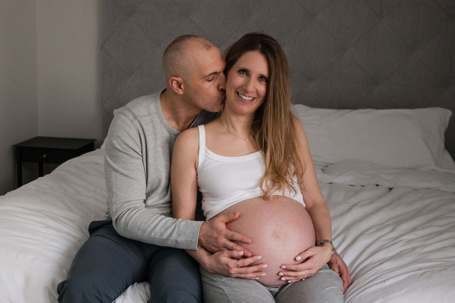 Expectant parents sharing a tender moment during an in-home maternity photography session in Toronto, celebrating love and new beginnings.