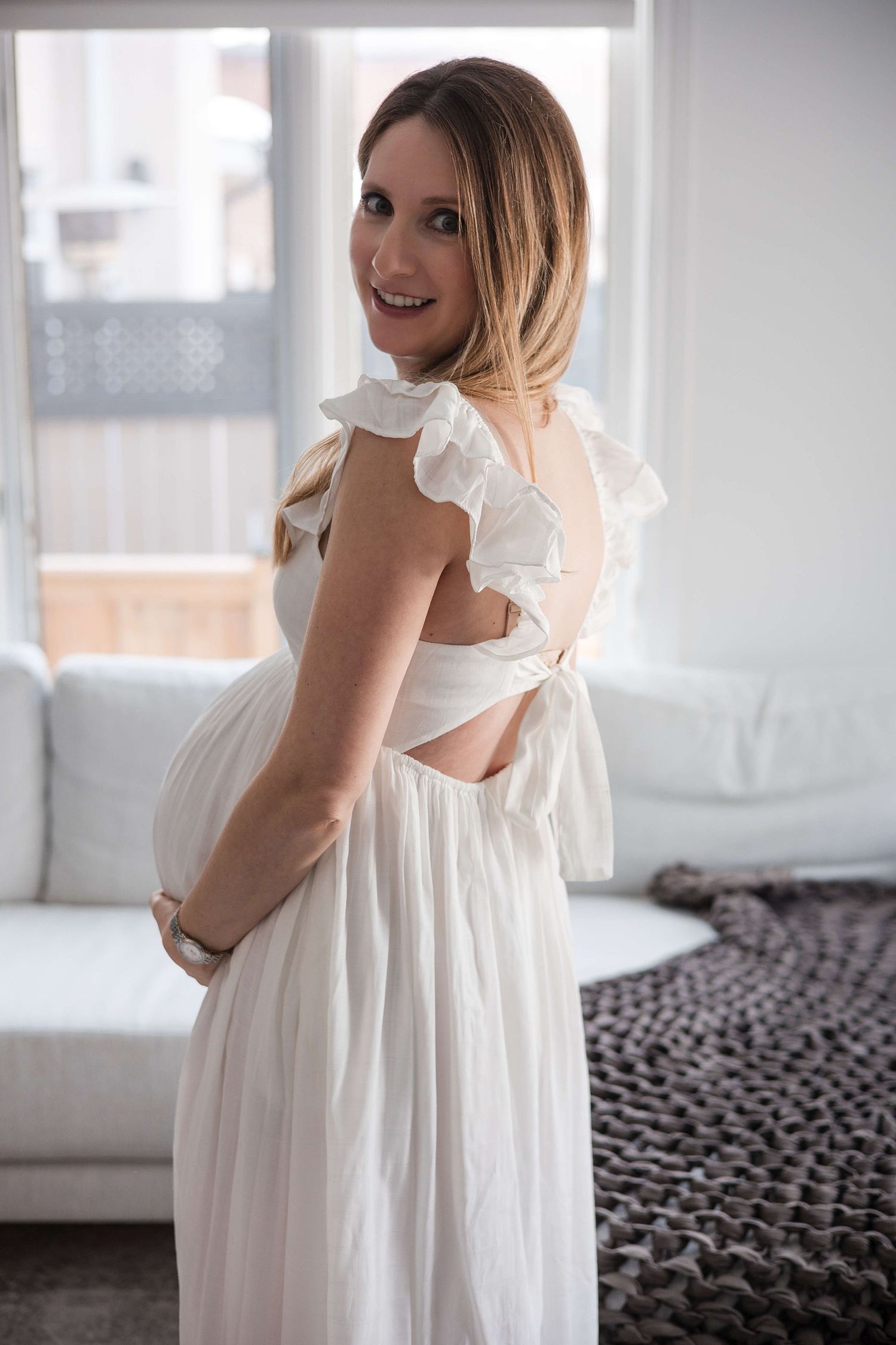 Expectant mother embracing her baby bump during an in-home maternity photography session in Toronto, capturing motherhood and anticipation.