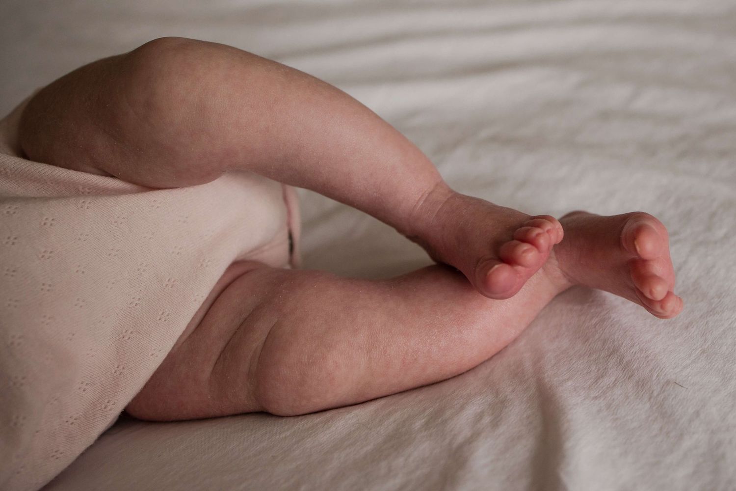 Close-up of a newborn’s tiny feet during an in-home newborn photography session in Toronto, capturing the smallest details of new life.