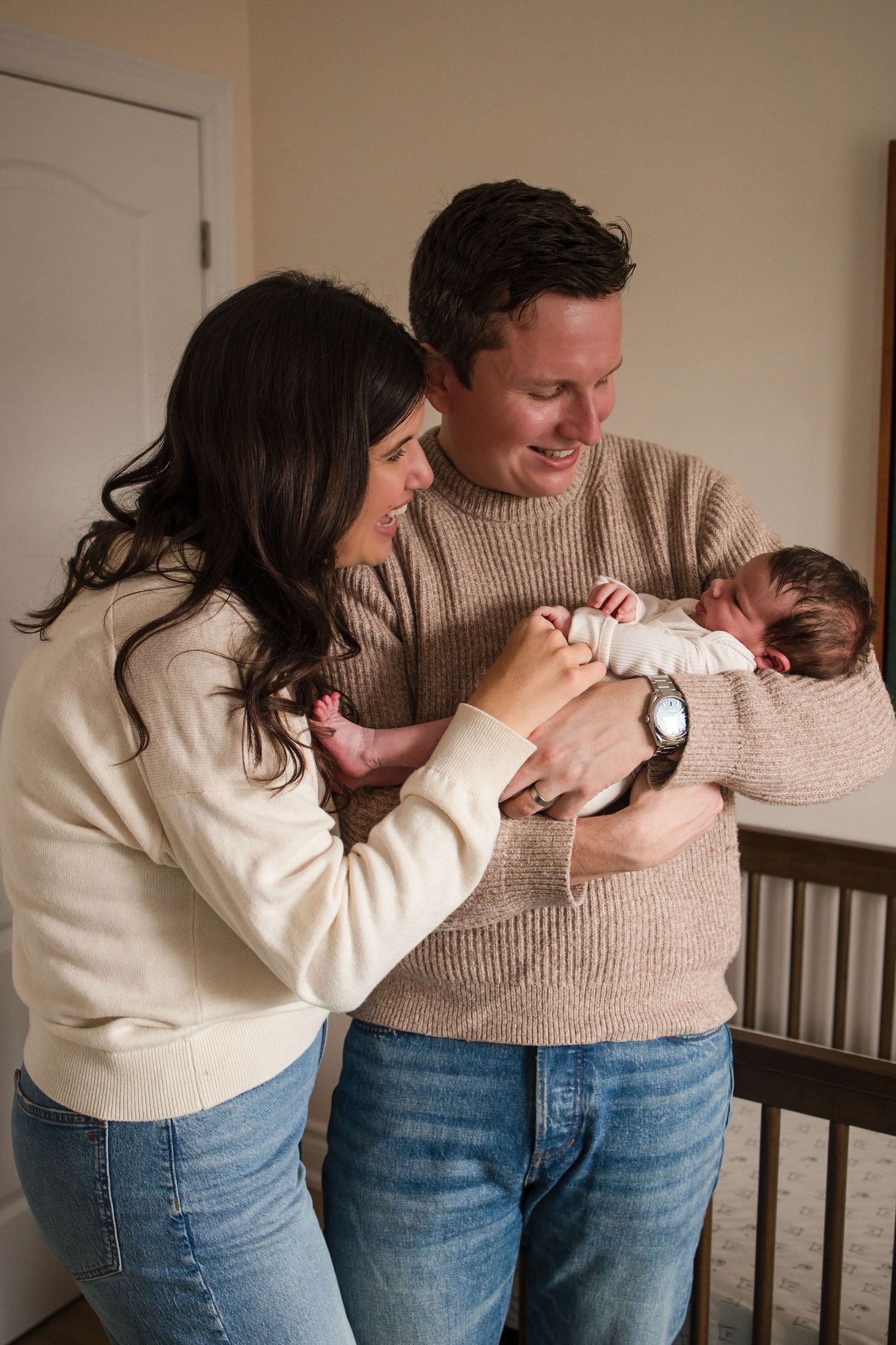 New parents admiring their newborn during a natural lifestyle newborn photography session in Toronto.