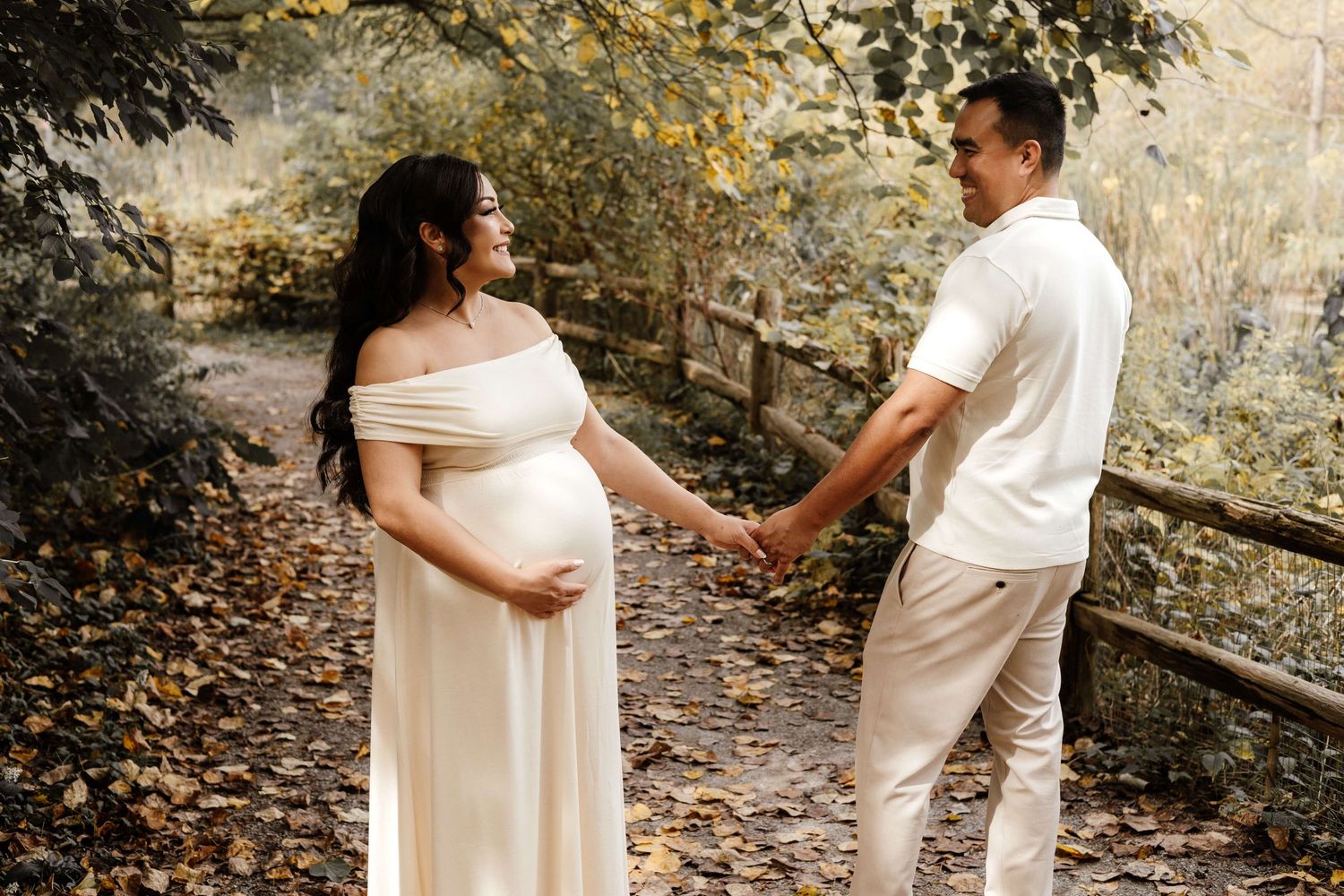 Expectant parents sharing a joyful moment at Evergreen Brick Works during an outdoor maternity photography session in Toronto.