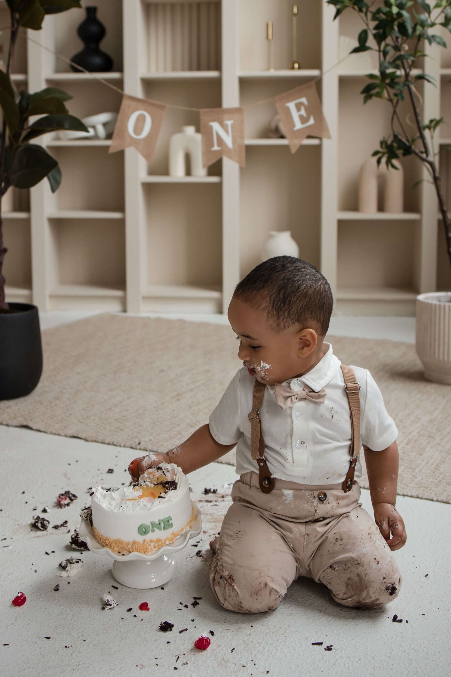One-year-old enjoying a cake smash session at Mint Room Studios in Toronto with a simple neutral setup, timeless decor, and natural style.